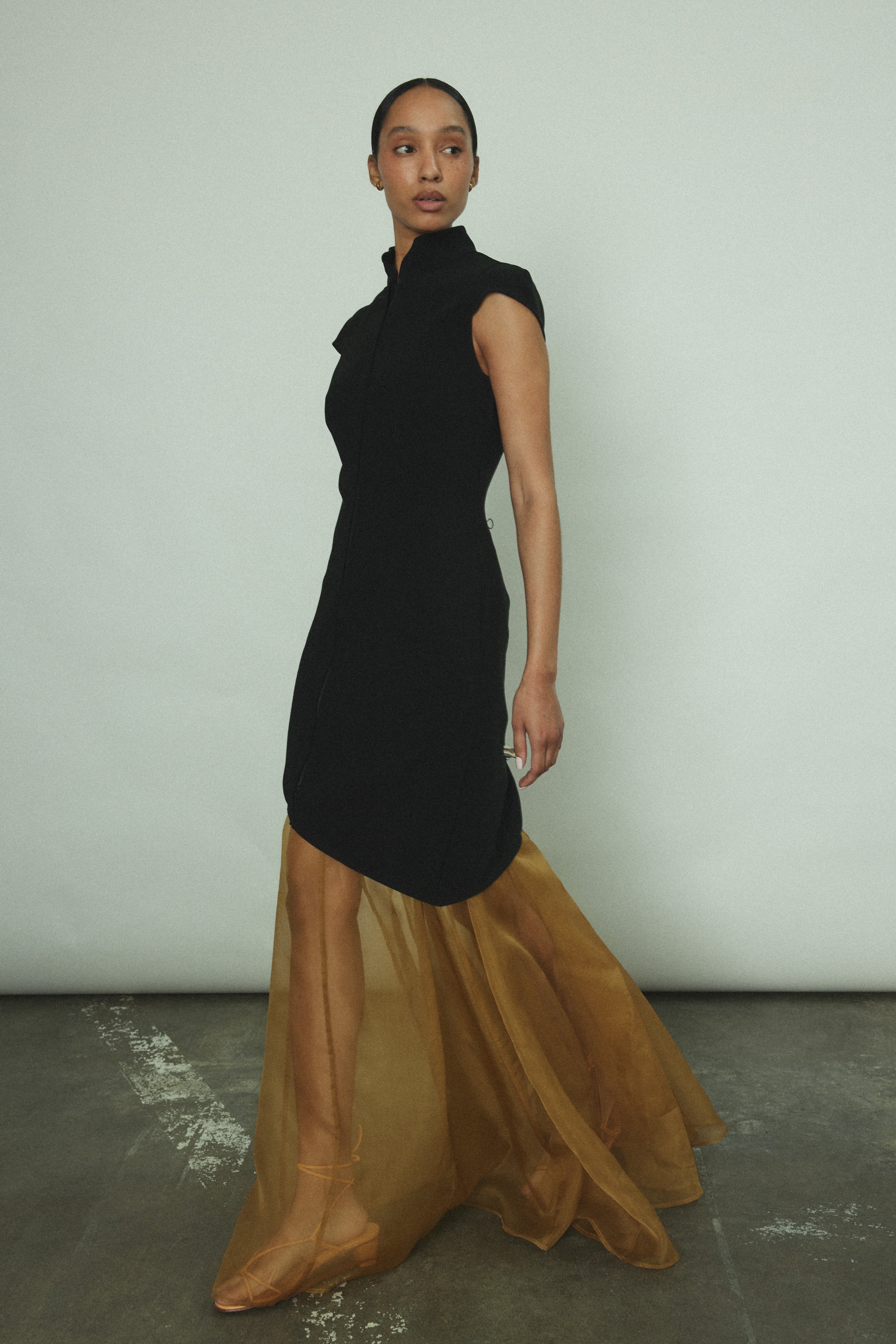 Side view of the black wool flannel Kamperett Astrid Vest showing the asymmetric hemline.
