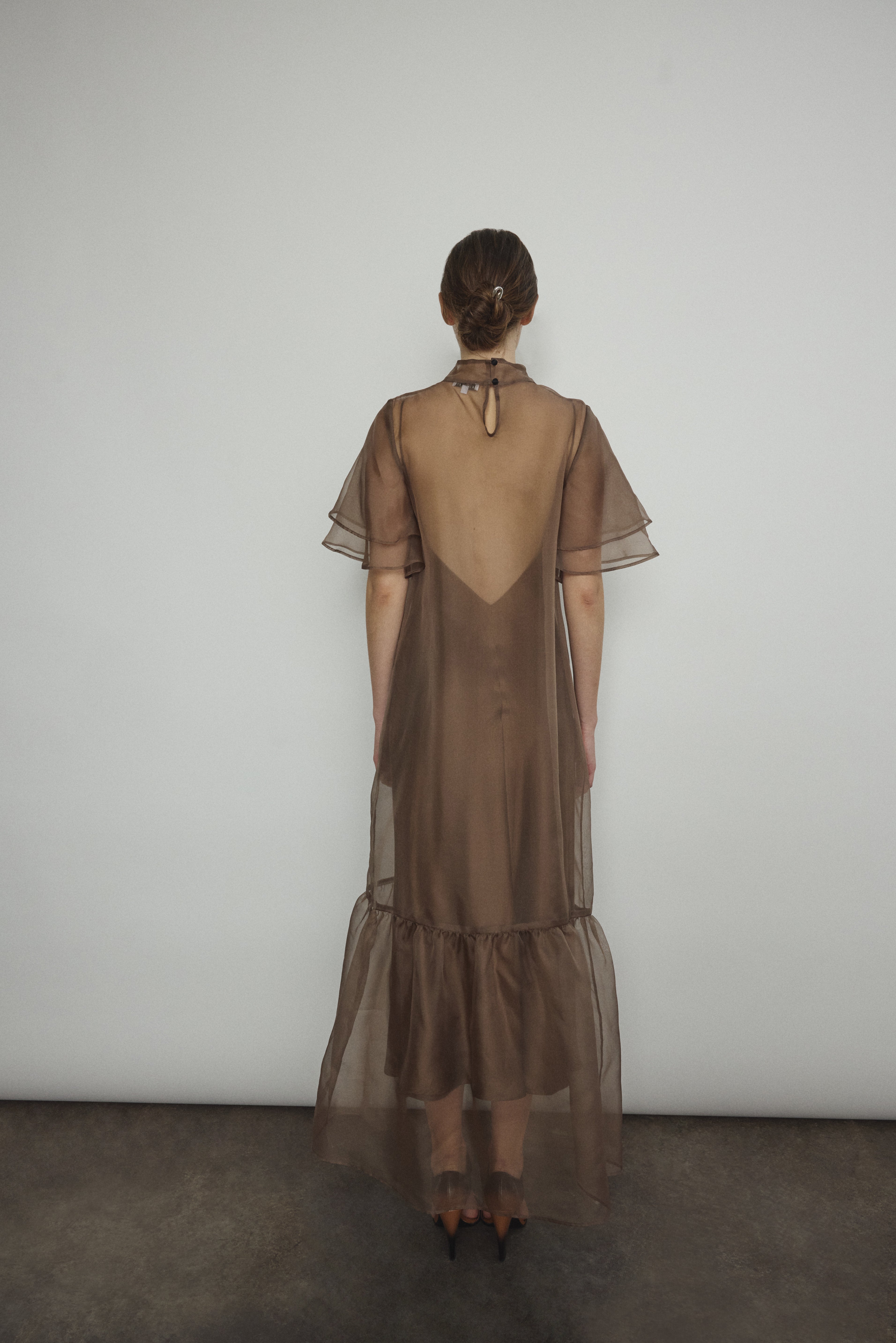 Model in a voluminous mushroom silk organza Barre maxi dress with oversized ruffles and tiered sleeves.