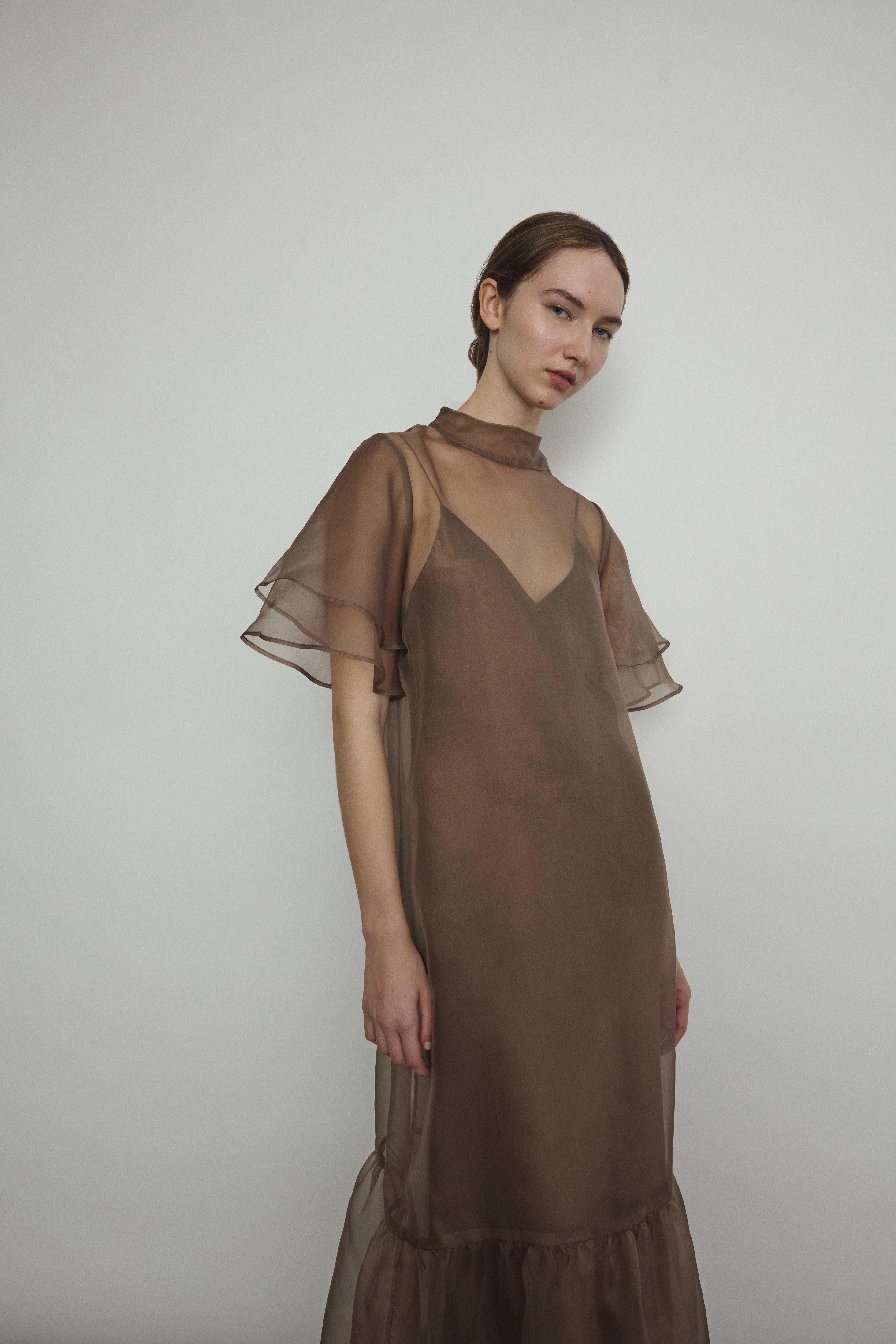 Model in a voluminous mushroom silk organza Barre maxi dress with oversized ruffles and tiered sleeves.