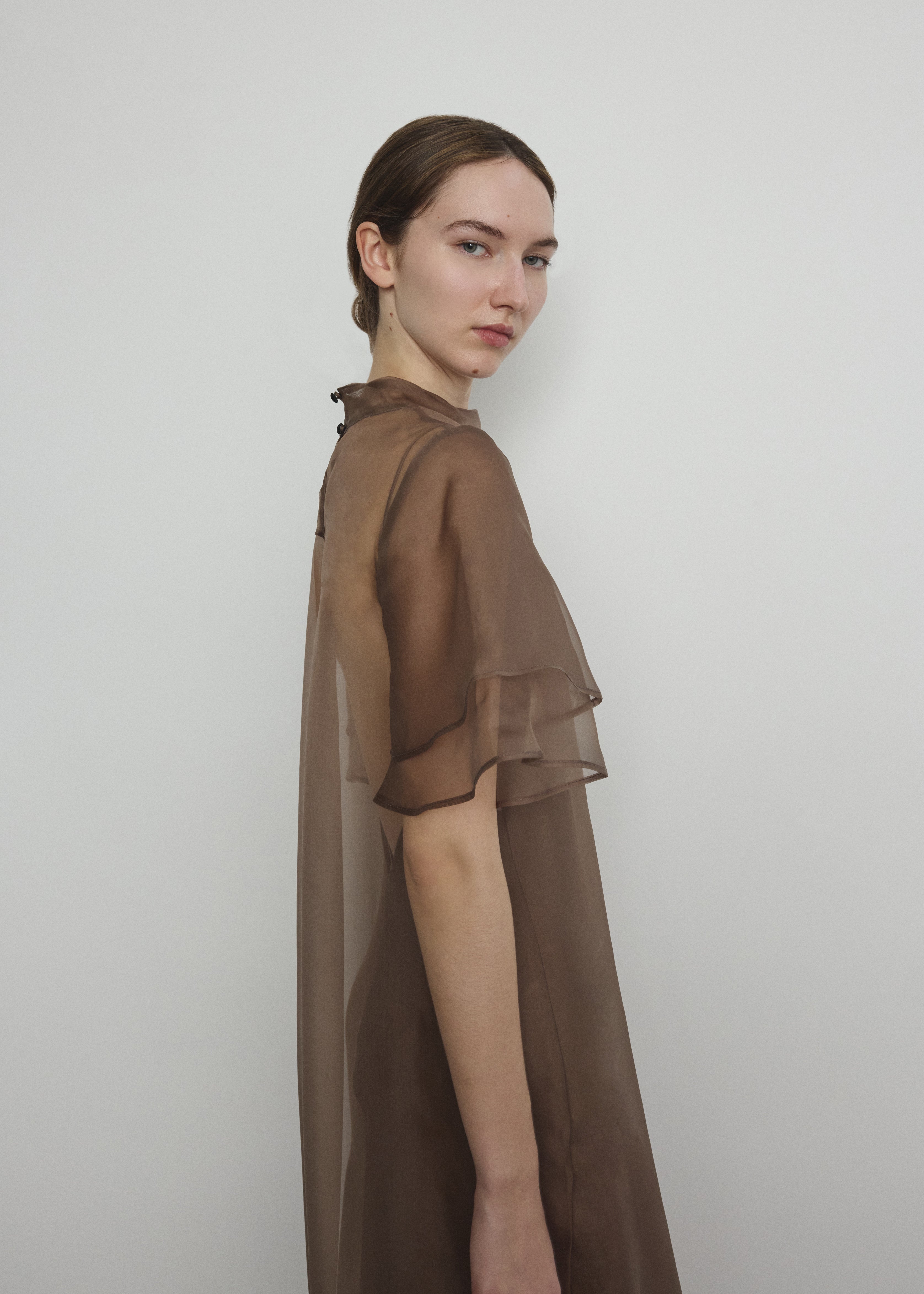 Model in a voluminous mushroom silk organza Barre maxi dress with oversized ruffles and tiered sleeves.