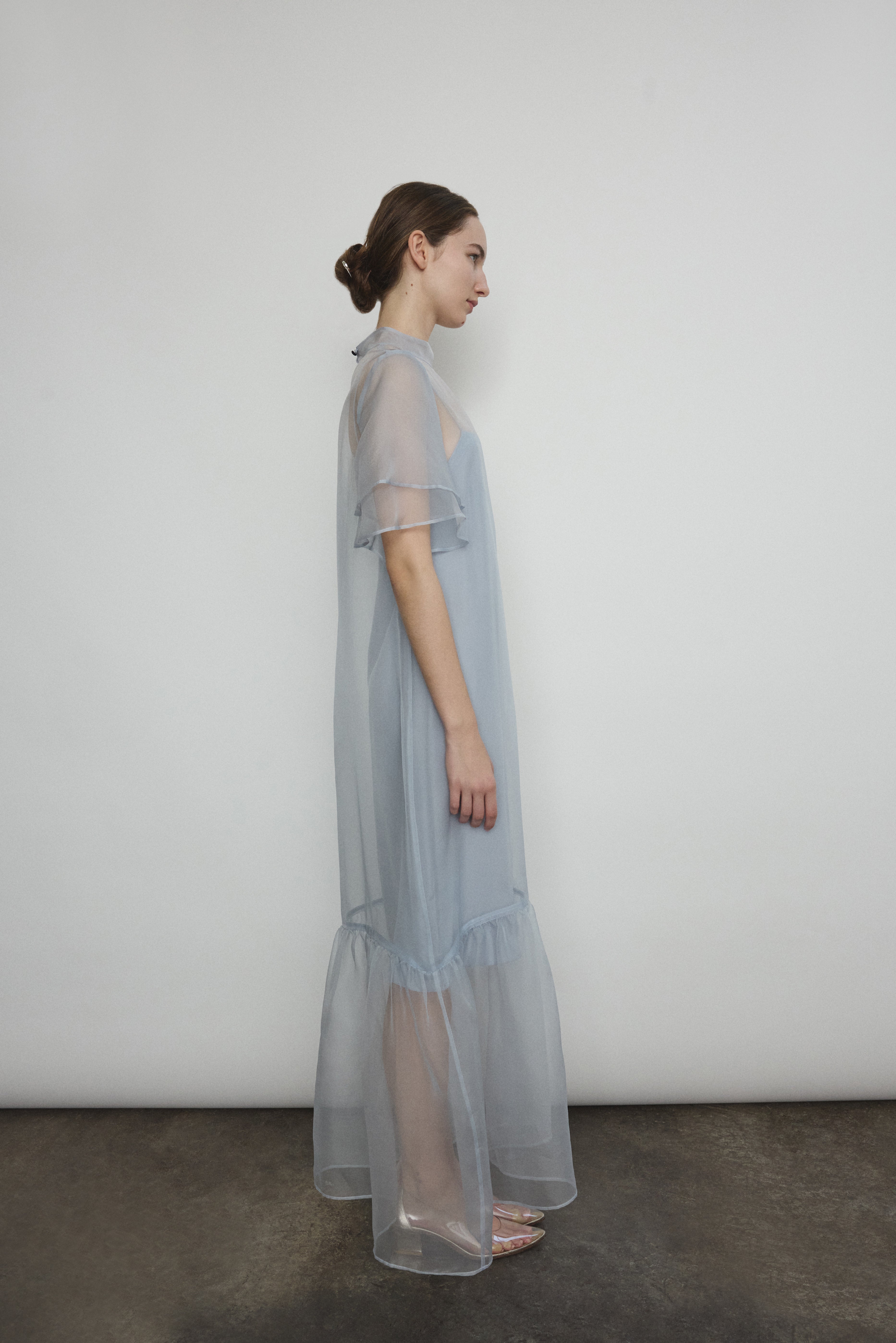 Model in a voluminous blue silk organza Barre maxi dress with oversized ruffles and tiered sleeves.