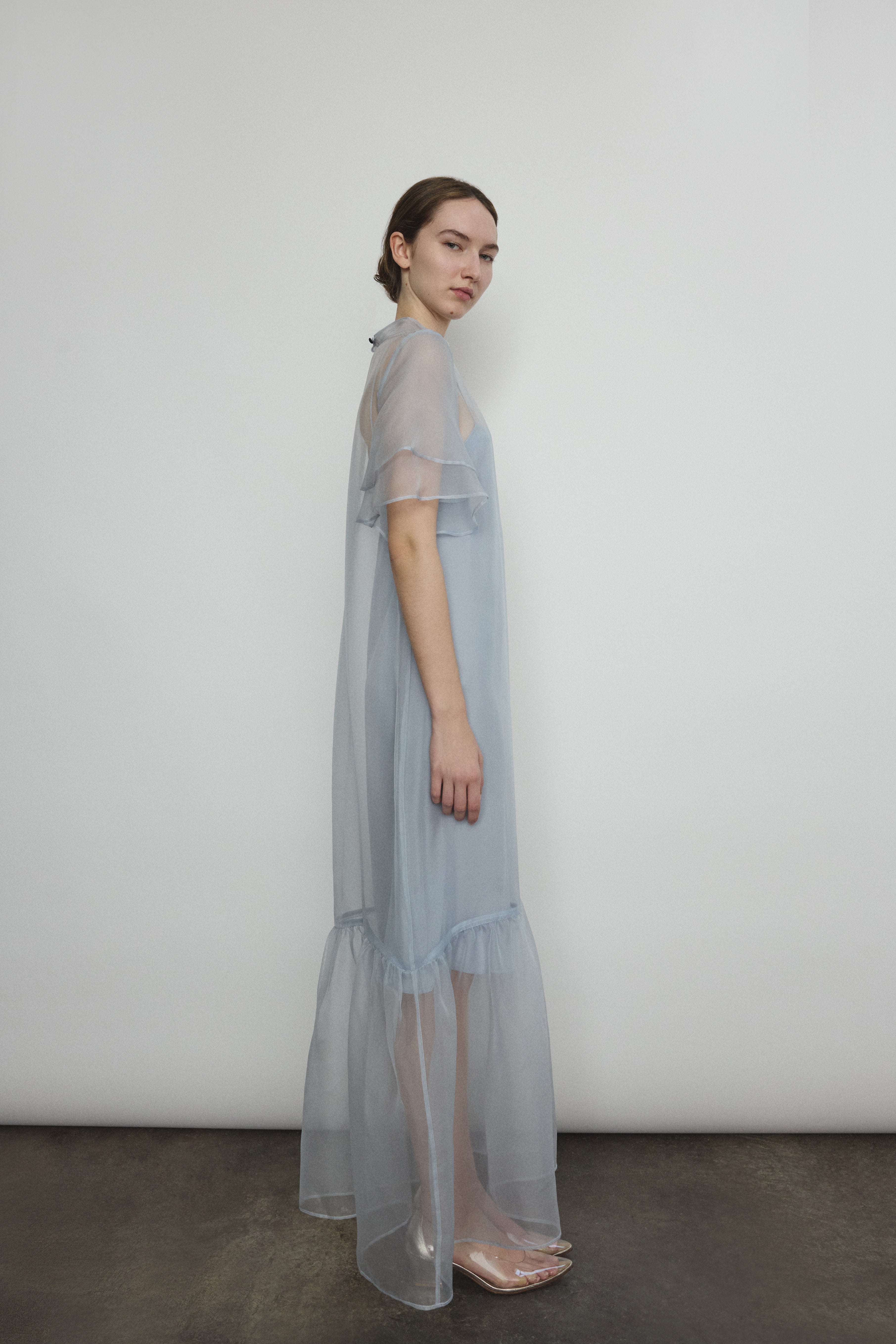 Model in a voluminous blue silk organza Barre maxi dress with oversized ruffles and tiered sleeves.