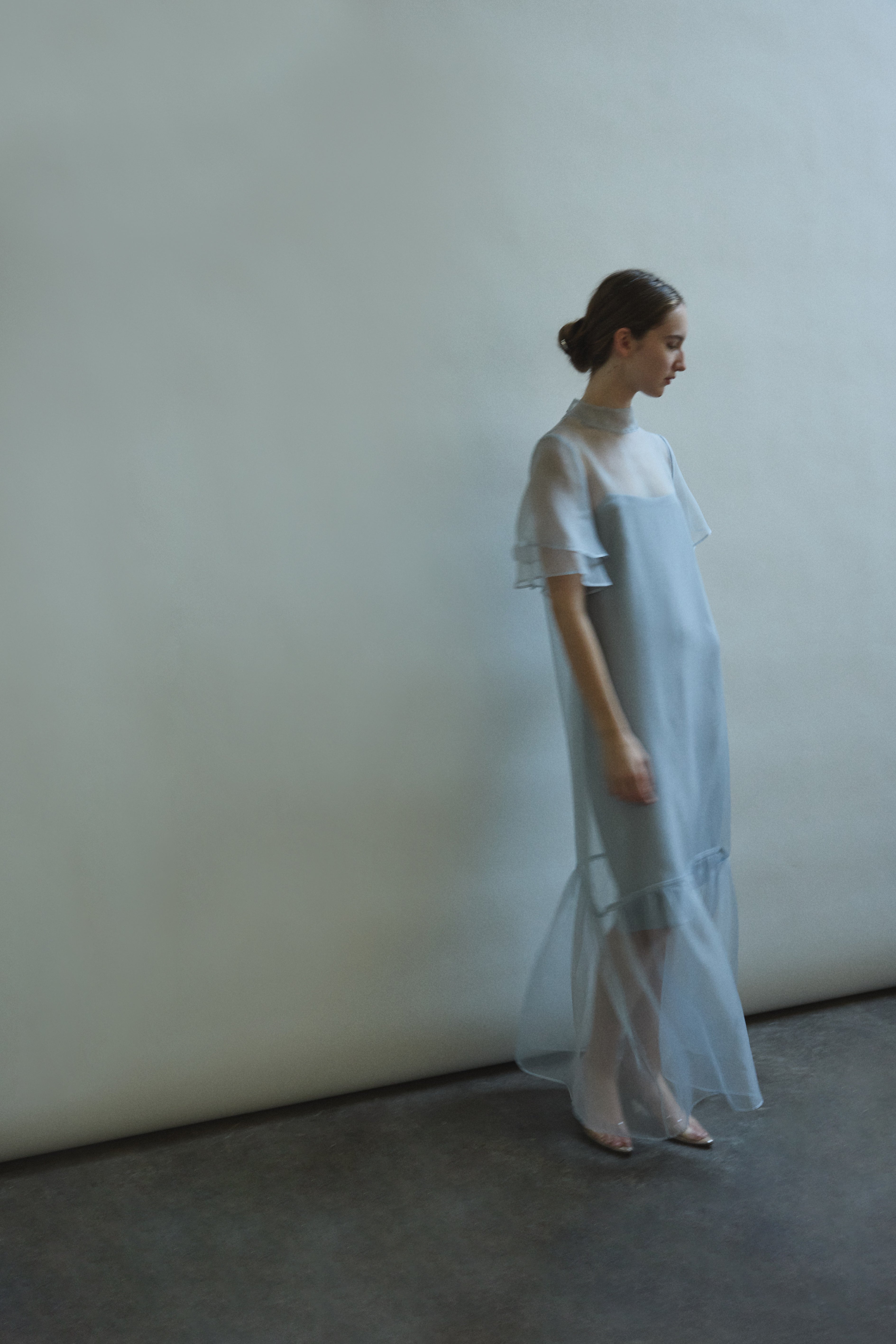 Model in a voluminous blue silk organza Barre maxi dress with oversized ruffles and tiered sleeves.
