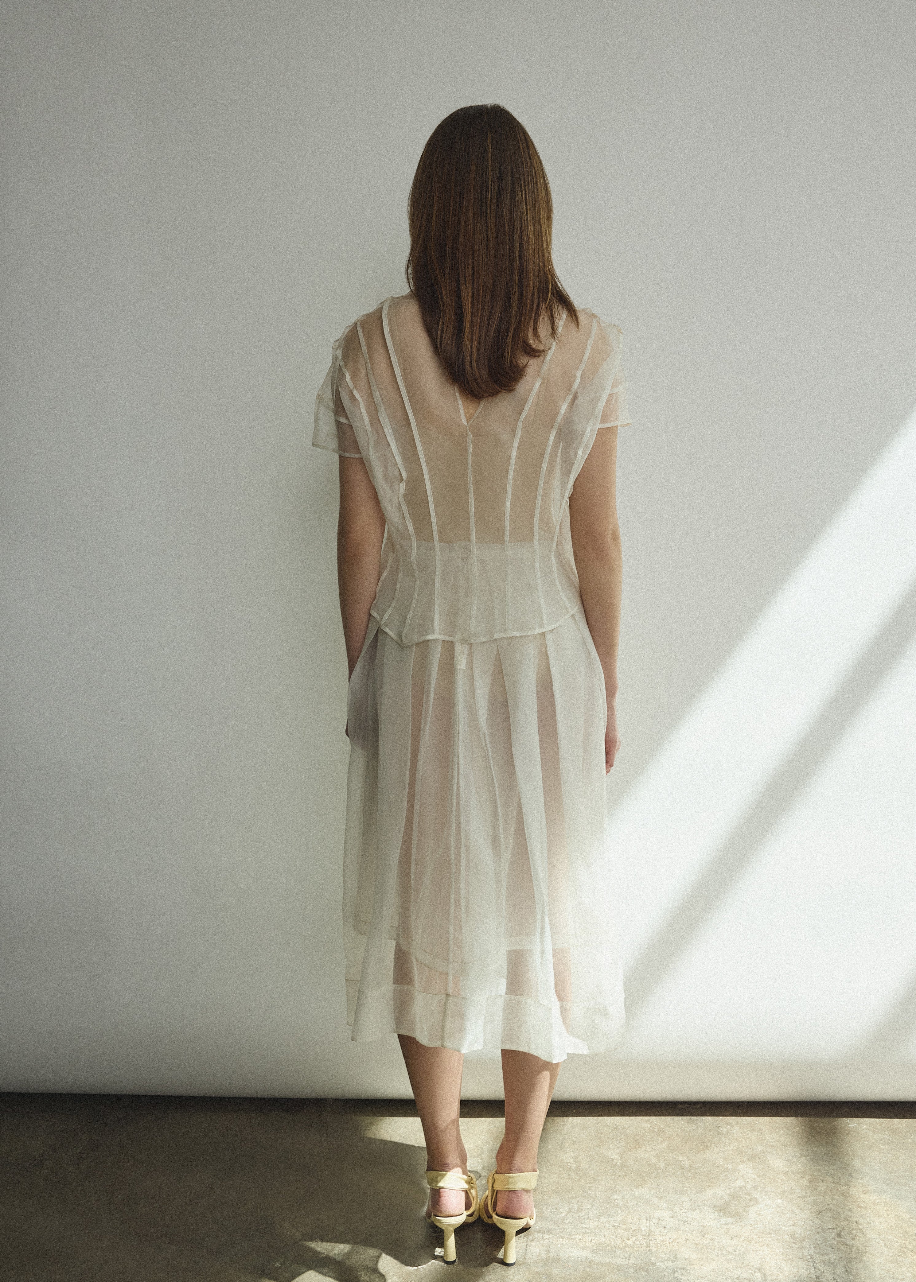 Model wearing the Alabaster silk organza Brise Skirt, showcasing its voluminous silhouette, sheer fabric, and elegant midi-length drape.