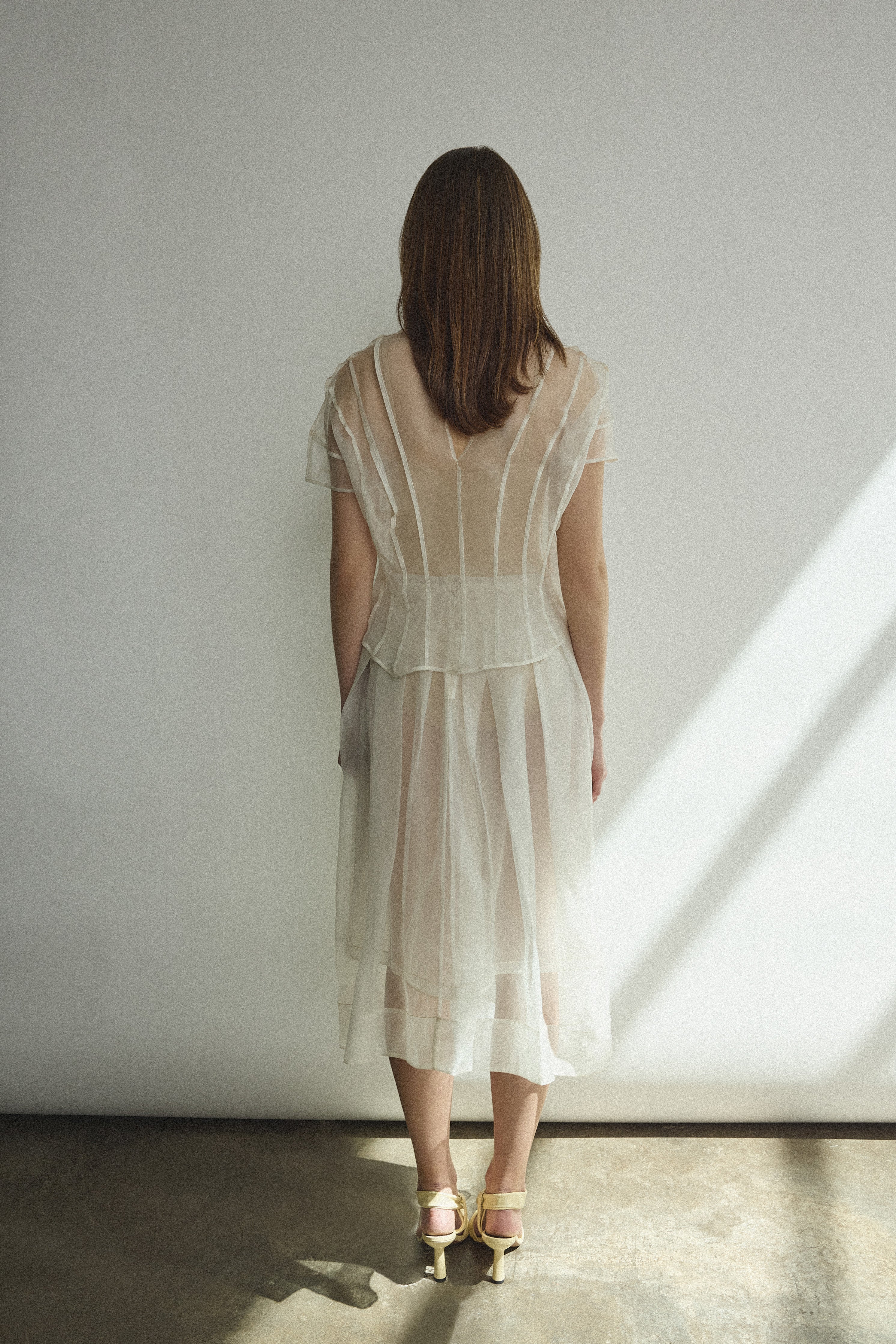 Model wearing the Alabaster silk organza Brise Skirt, showcasing its voluminous silhouette, sheer fabric, and elegant midi-length drape.