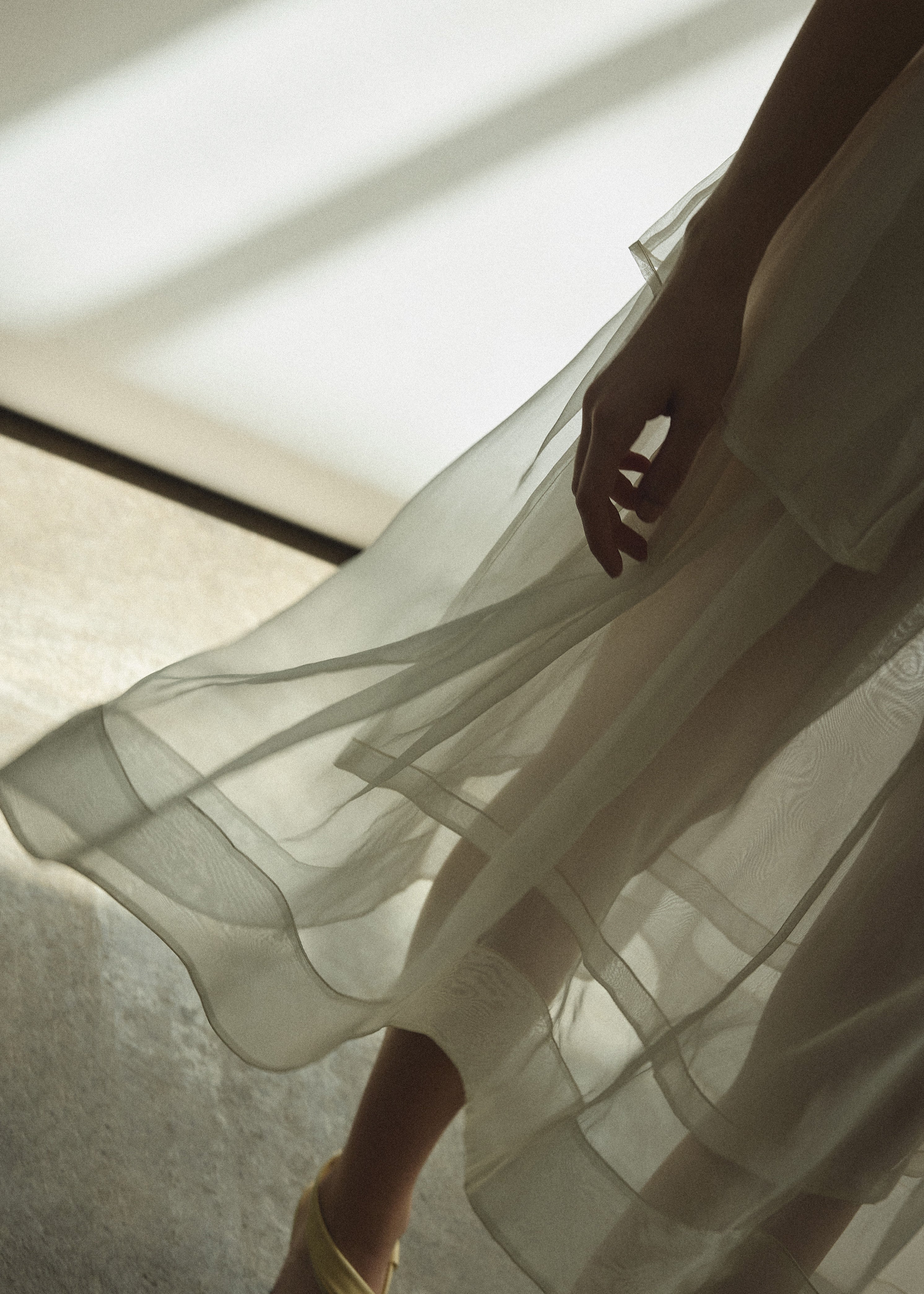 Model wearing the Alabaster silk organza Brise Skirt, showcasing its voluminous silhouette, sheer fabric, and elegant midi-length drape.