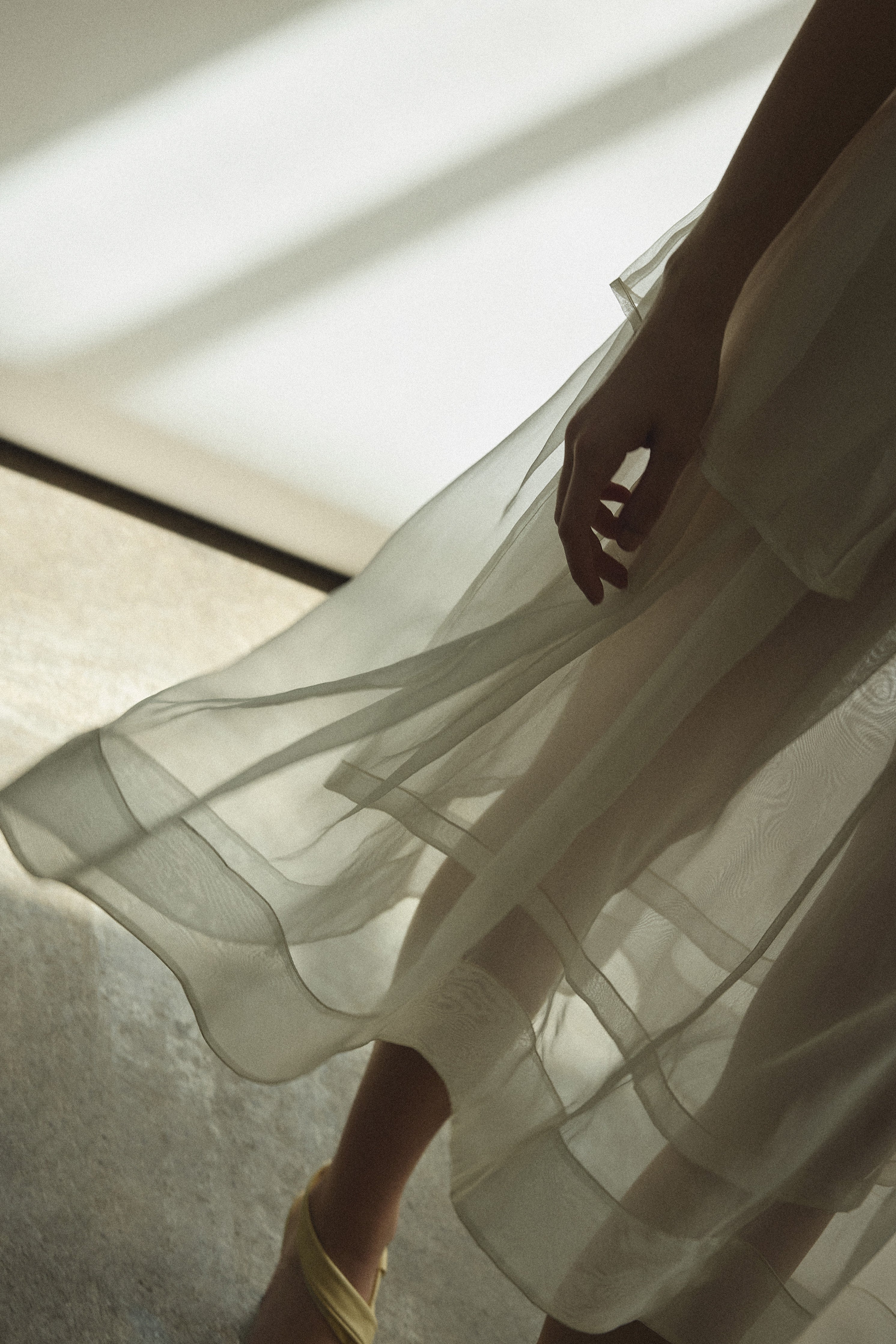 Model wearing the Alabaster silk organza Brise Skirt, showcasing its voluminous silhouette, sheer fabric, and elegant midi-length drape.