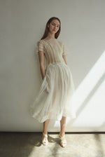 Model wearing the Alabaster silk organza Brise Skirt, showcasing its voluminous silhouette, sheer fabric, and elegant midi-length drape.