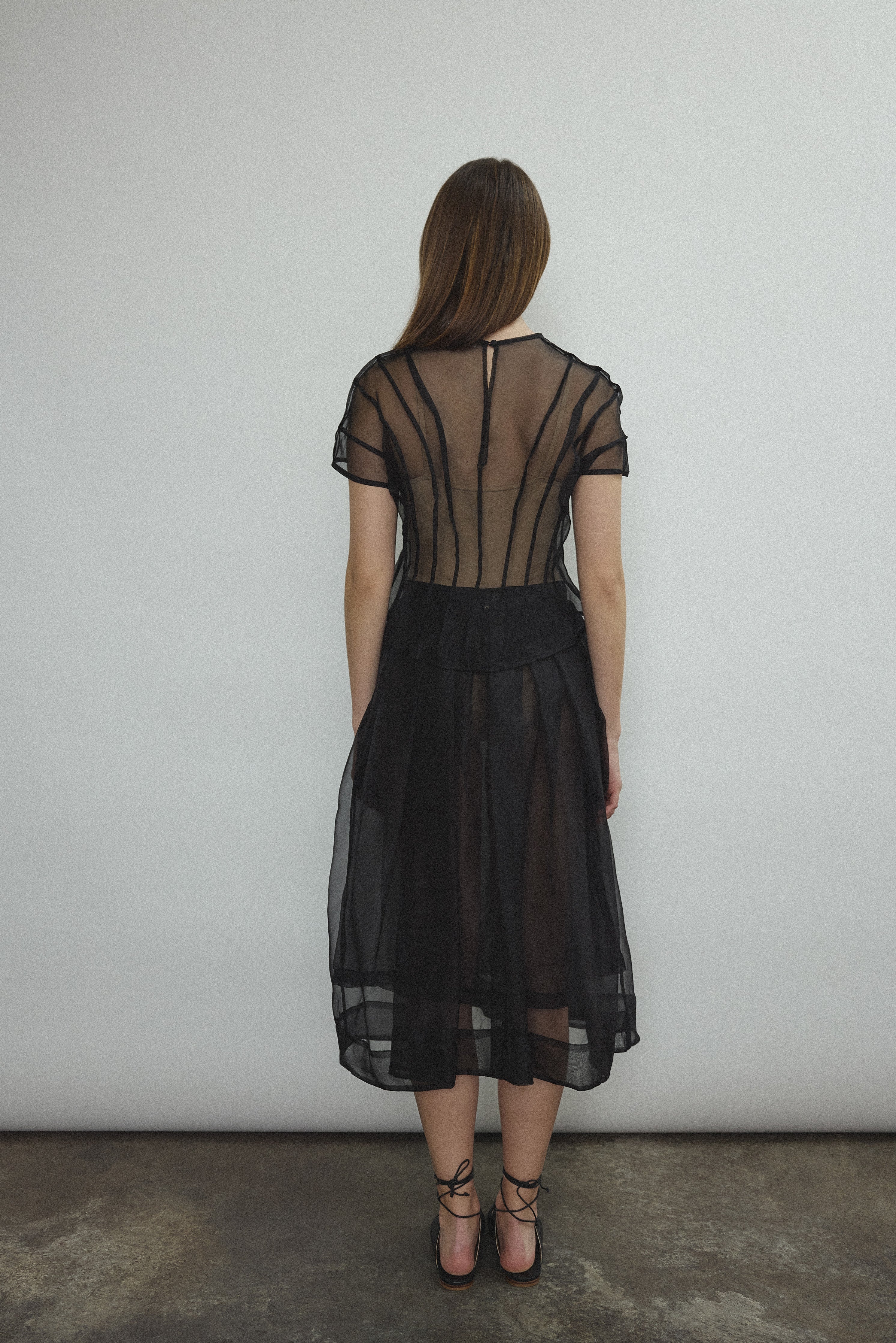 Model wearing the Black silk organza Brise Skirt, showcasing its voluminous silhouette, sheer fabric, and elegant midi-length drape.