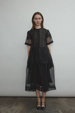 Model wearing the Black silk organza Brise Skirt, showcasing its voluminous silhouette, sheer fabric, and elegant midi-length drape.