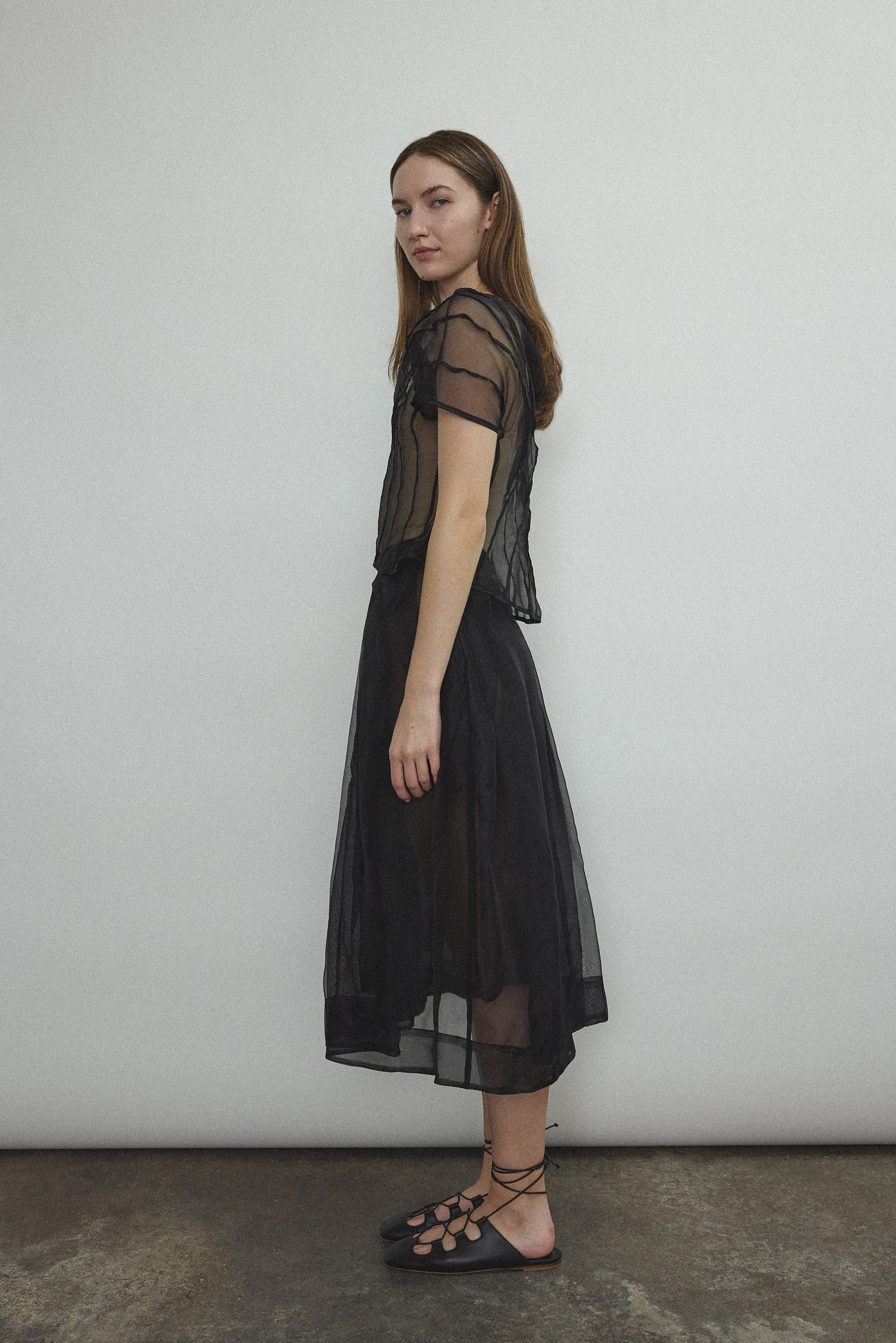 Model wearing the Black silk organza Brise Skirt, showcasing its voluminous silhouette, sheer fabric, and elegant midi-length drape.