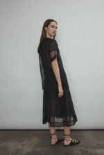 Model wearing the Black silk organza Brise Skirt, showcasing its voluminous silhouette, sheer fabric, and elegant midi-length drape.