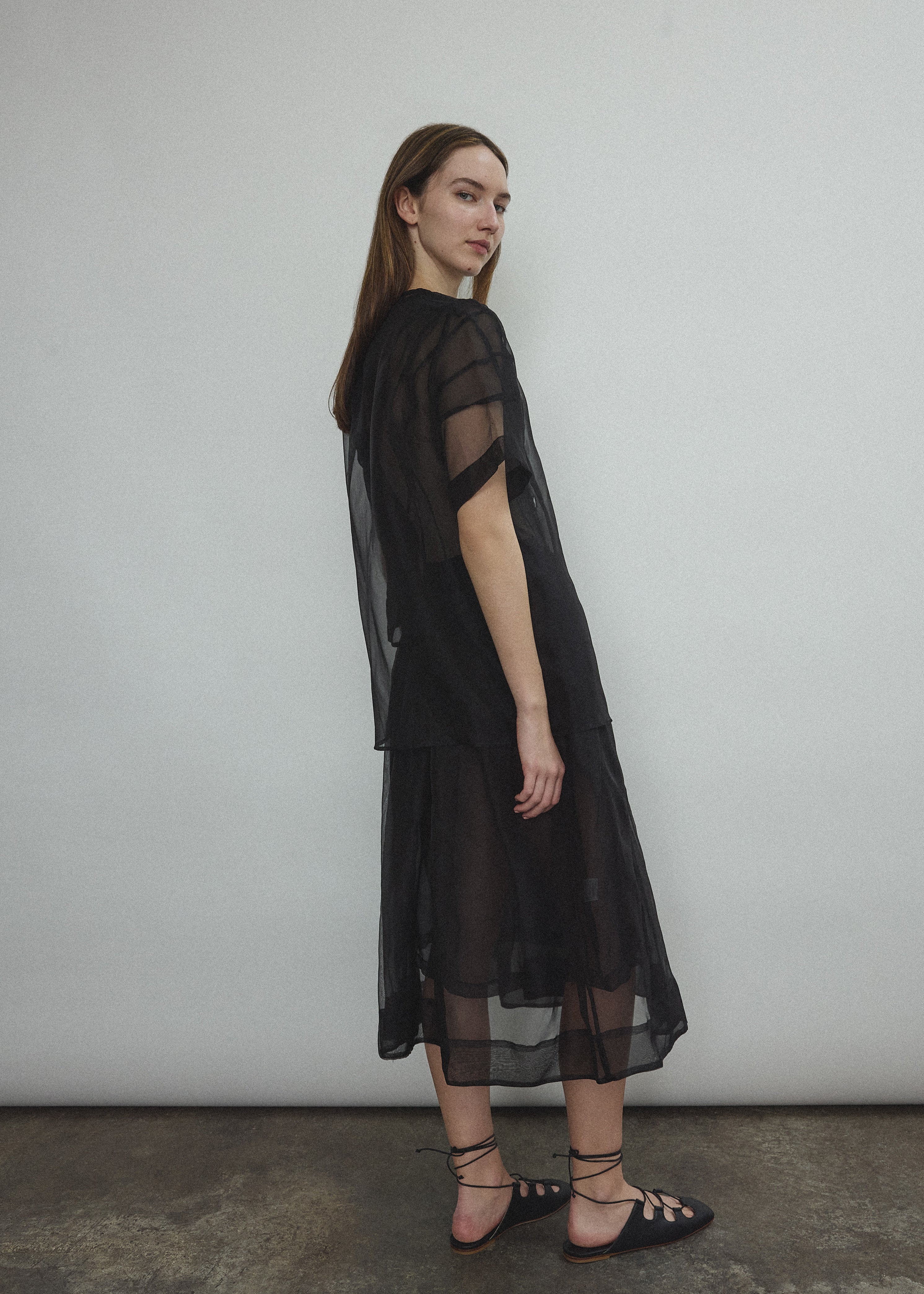 Model wearing the Black silk organza Brise Skirt, showcasing its voluminous silhouette, sheer fabric, and elegant midi-length drape.