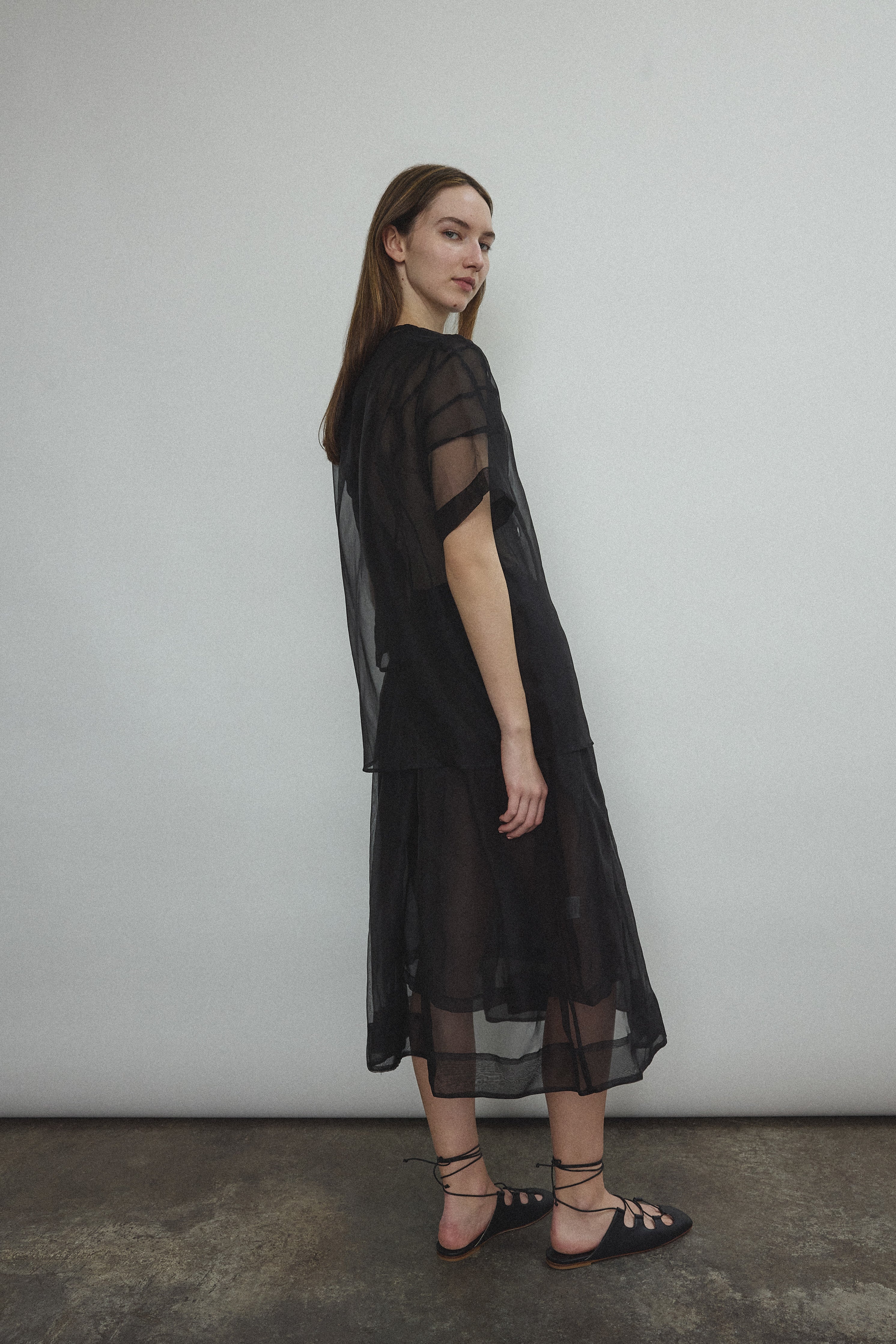 Model wearing the Black silk organza Brise Skirt, showcasing its voluminous silhouette, sheer fabric, and elegant midi-length drape.