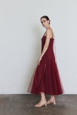 Side view of the bordeaux sheer tulle Kamperett Camille Dress showing the multi-godet full skirt.
