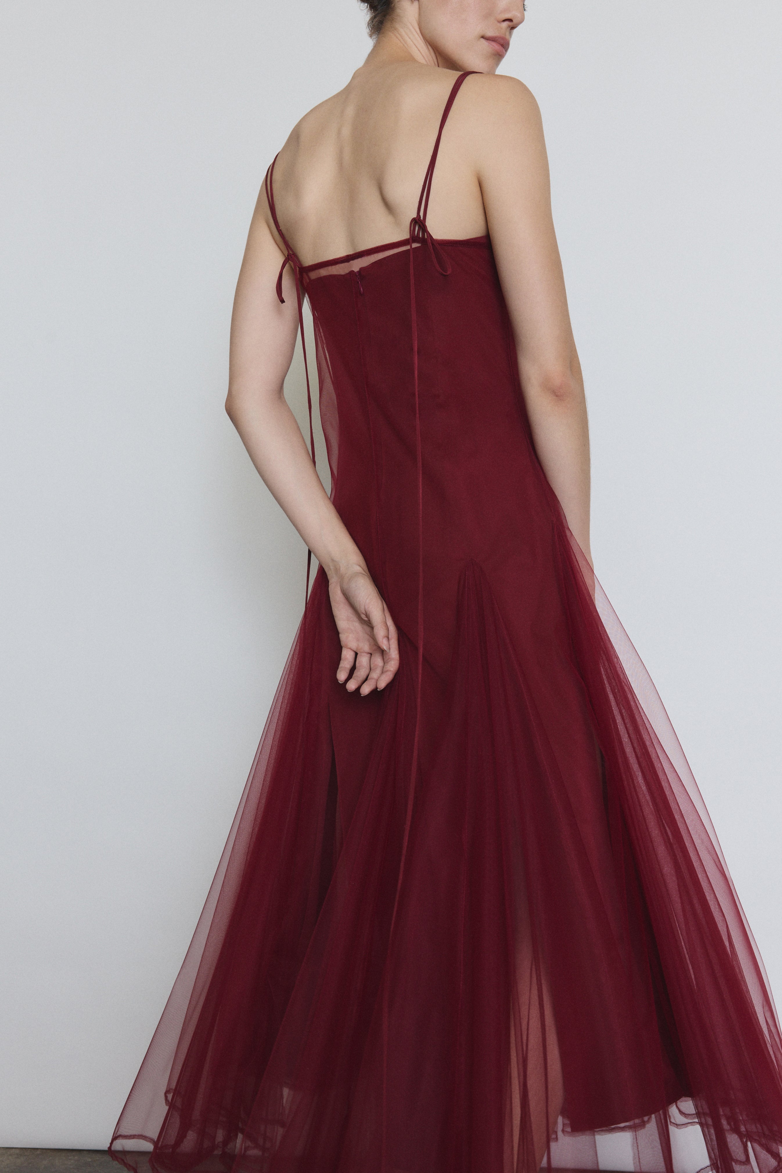 Model wearing the bordeaux Kamperett Camille Dress layered over the Theodora Slip Dress in Bordeaux.