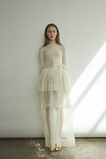 Front view of a bride wearing the alabaster sheer silk organza Kamperett Canna Skirt, a multi-tiered pleated maxi skirt.
