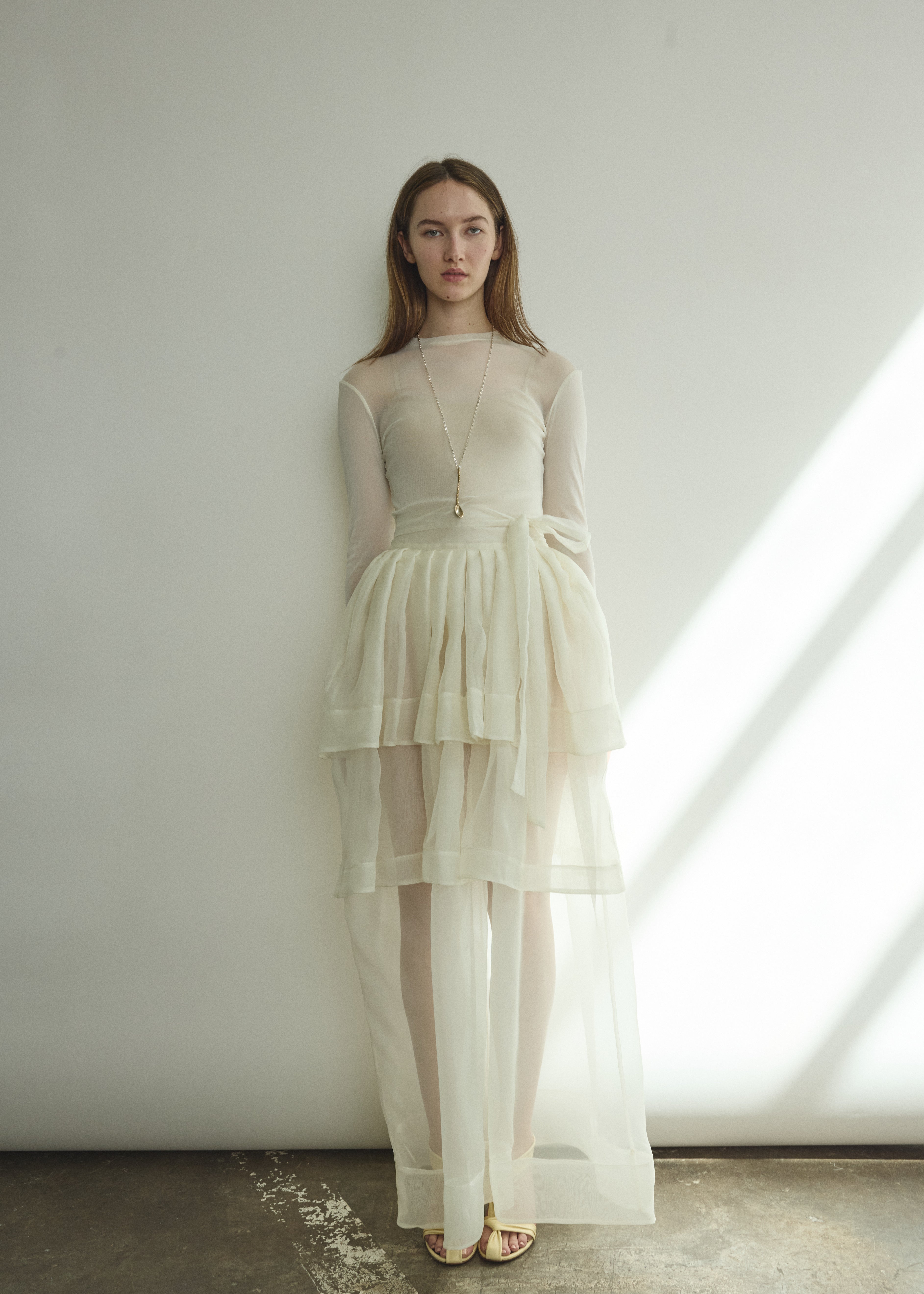 Front view of a bride wearing the alabaster sheer silk organza Kamperett Canna Skirt, a multi-tiered pleated maxi skirt.