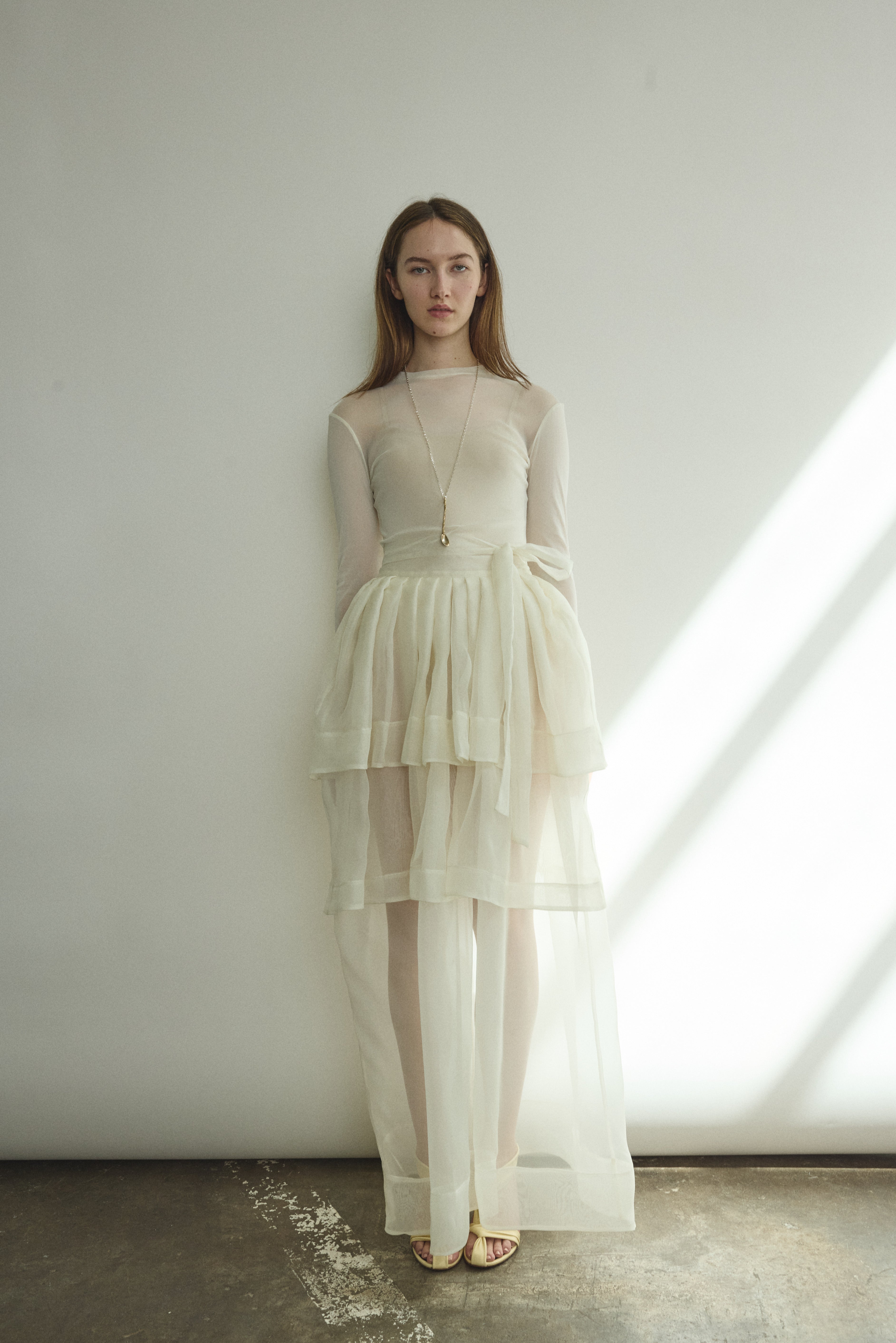 Front view of a bride wearing the alabaster sheer silk organza Kamperett Canna Skirt, a multi-tiered pleated maxi skirt.