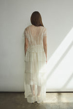 Back view of the alabaster Kamperett Canna Skirt layered over the Brise Skirt with waist ties tied at back.