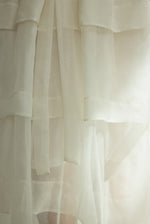 Detail of the alabaster Kamperett Canna Skirt layered over the Brise Skirt showing the multi-tier silk organza pleats.