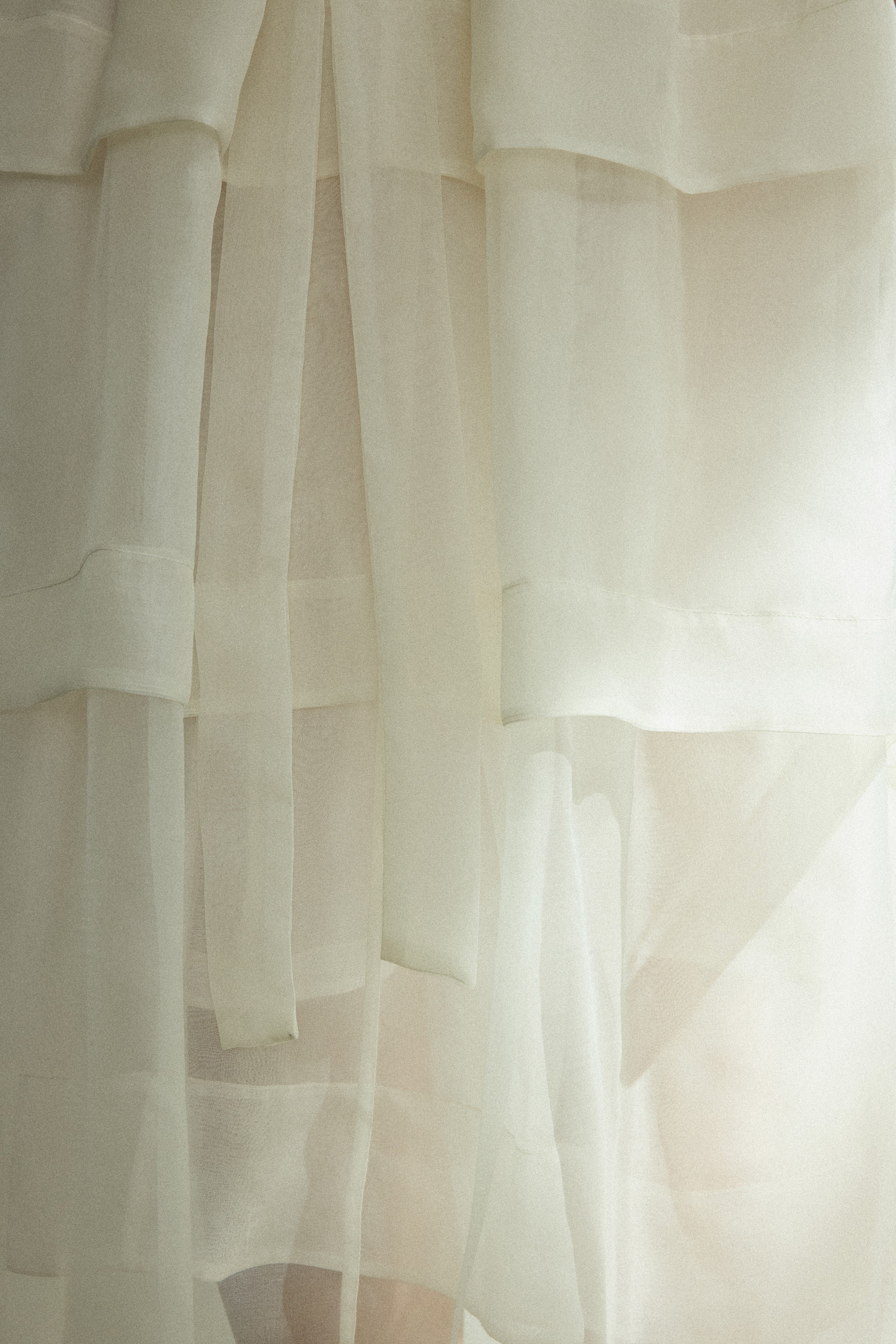Detail of the alabaster Kamperett Canna Skirt layered over the Brise Skirt showing the multi-tier silk organza pleats.