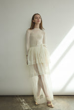 Side view of the alabaster sheer silk organza Kamperett Canna Skirt, showing the pleated multi-tier construction.