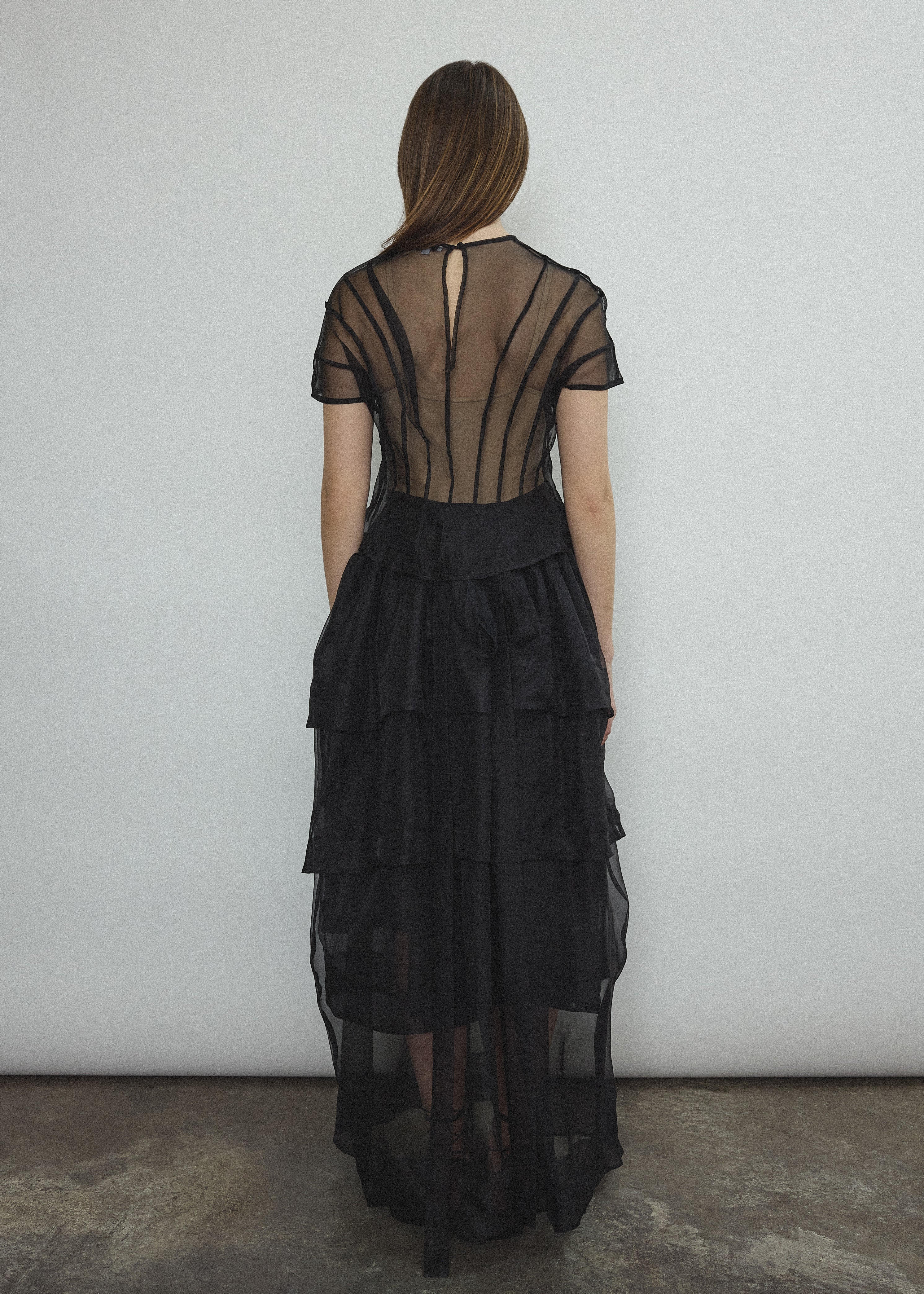 Back view of the black Kamperett Canna Skirt layered over the Brise Skirt with waist ties tied at back.