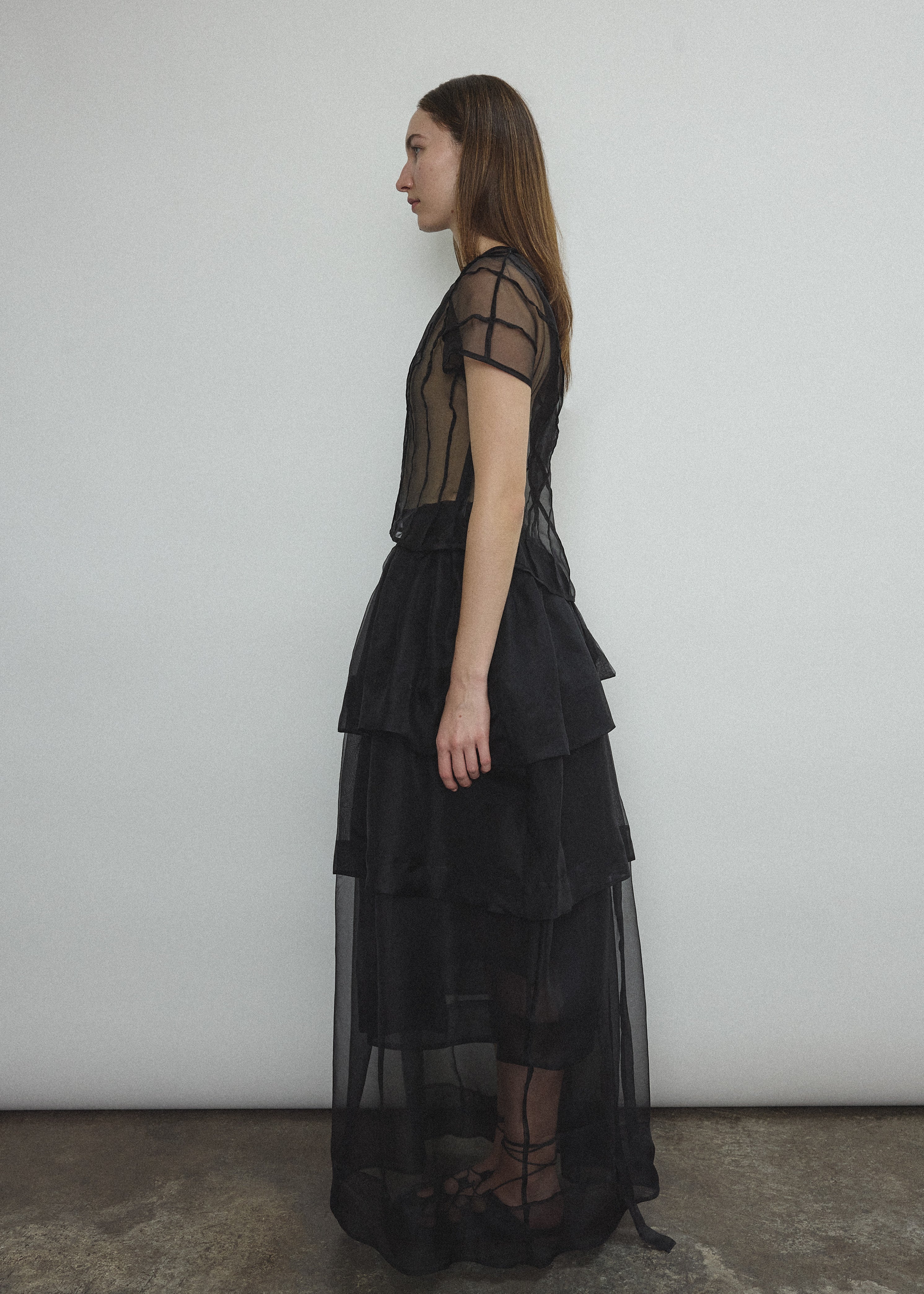 Side view of the black Kamperett Canna Skirt layered over the Brise Skirt showing the multi-tier silk organza pleats.