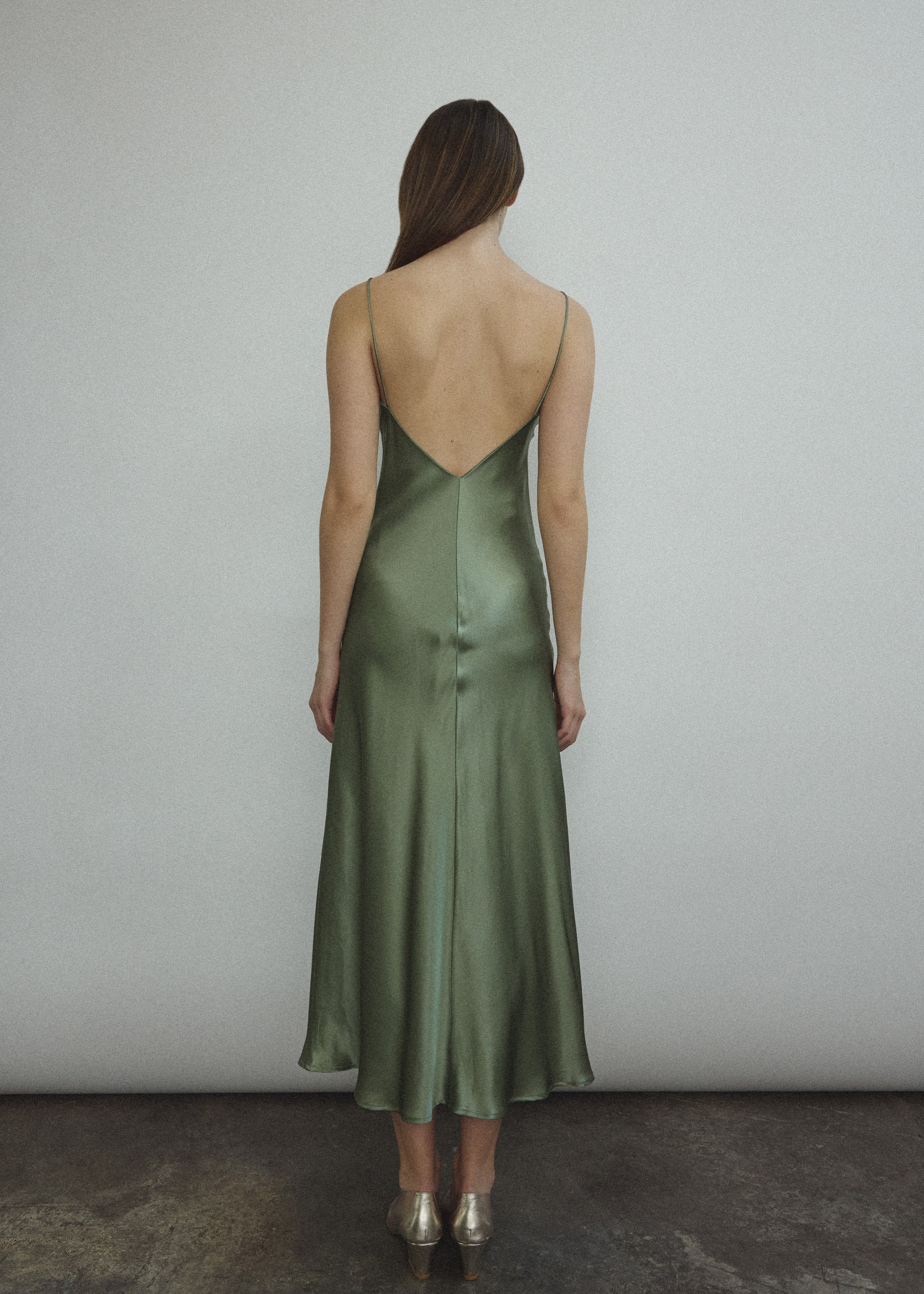 Back view of the jade sueded silk charmeuse Kamperett Caroline Midi Slip Dress with V-back neckline.