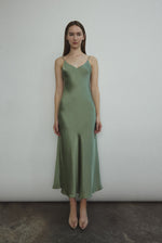 Front view of a model wearing the jade sueded silk charmeuse Kamperett Caroline Midi Slip Dress with V-neckline and corded straps.
