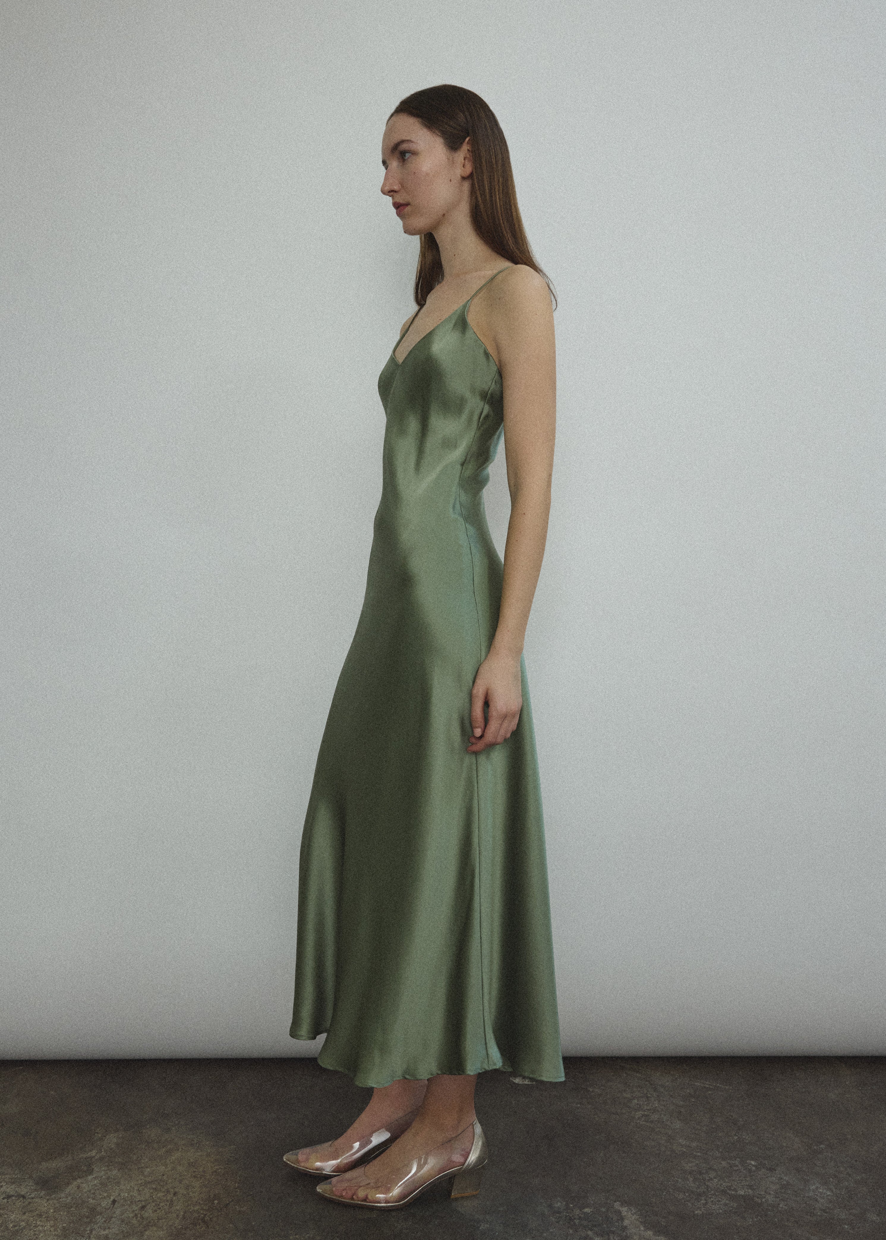 Side view of the jade sueded silk charmeuse Kamperett Caroline Midi Slip Dress, showing the bias-cut drape.