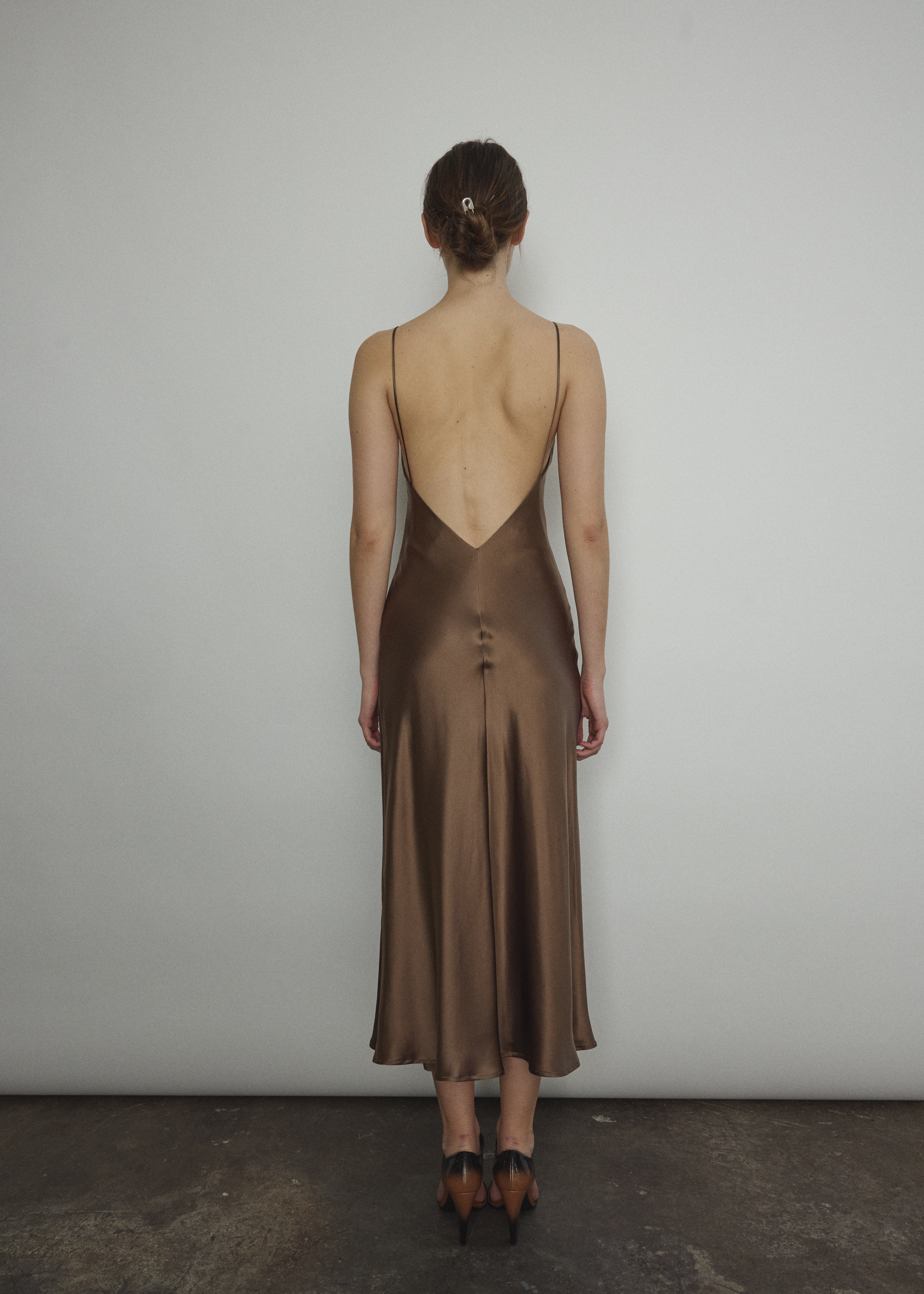 Back view of the mushroom sueded silk charmeuse Kamperett Caroline Midi Slip Dress with V-back neckline.
