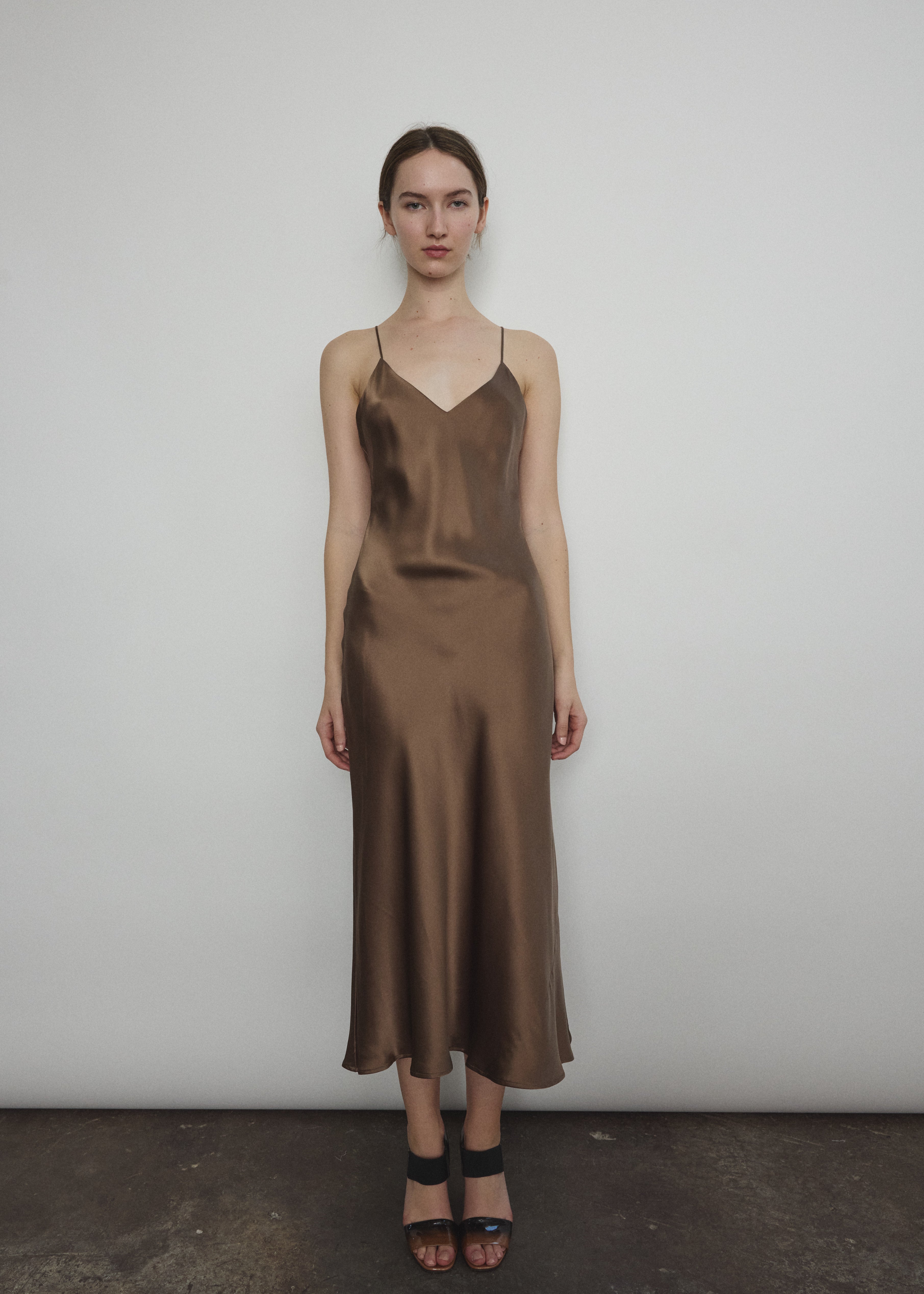 Front view of a model wearing the mushroom sueded silk charmeuse Kamperett Caroline Midi Slip Dress with V-neckline and corded straps.