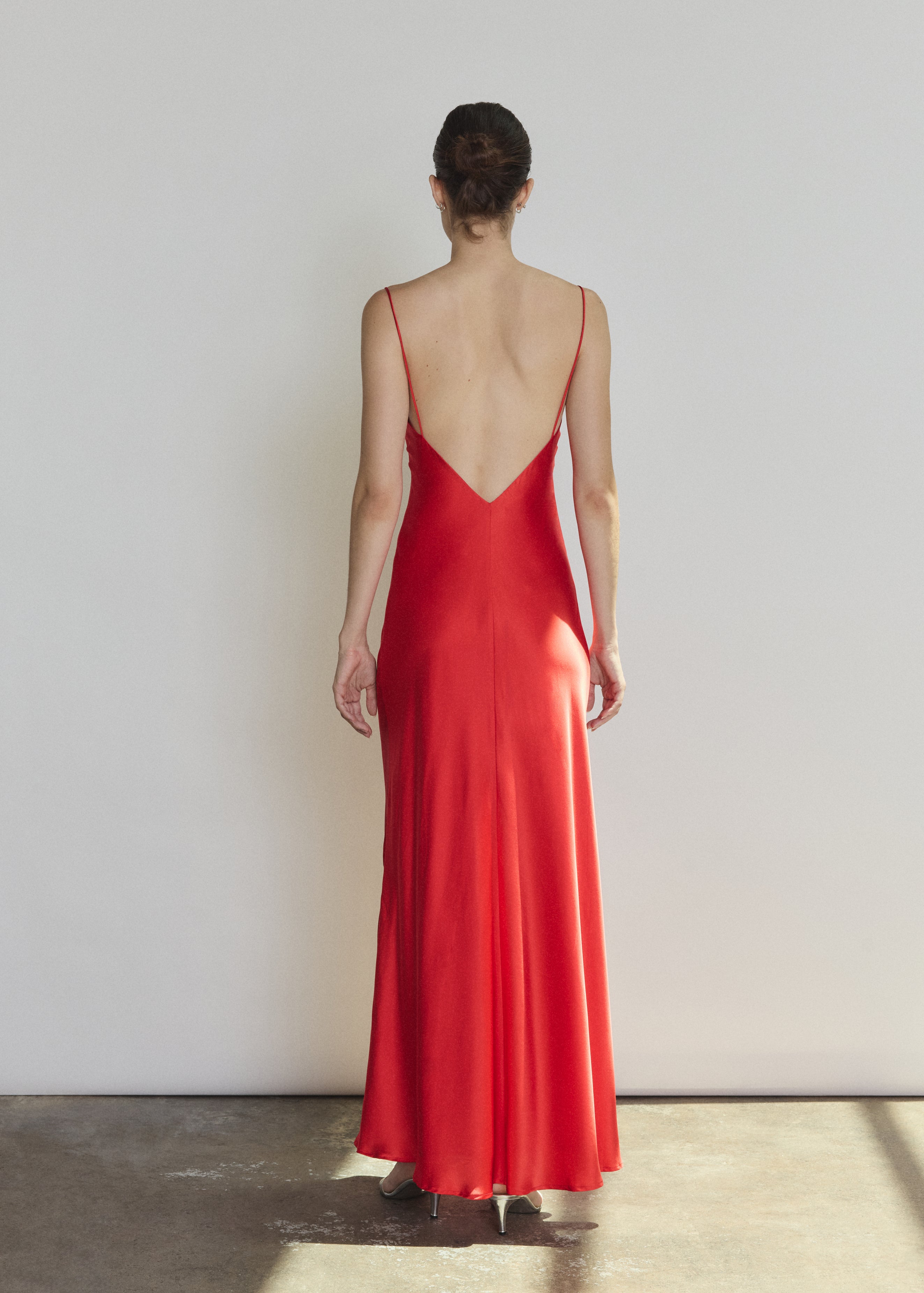 Back view of the crimson silk charmeuse Kamperett Caroline Slip Dress with V back and corded straps.