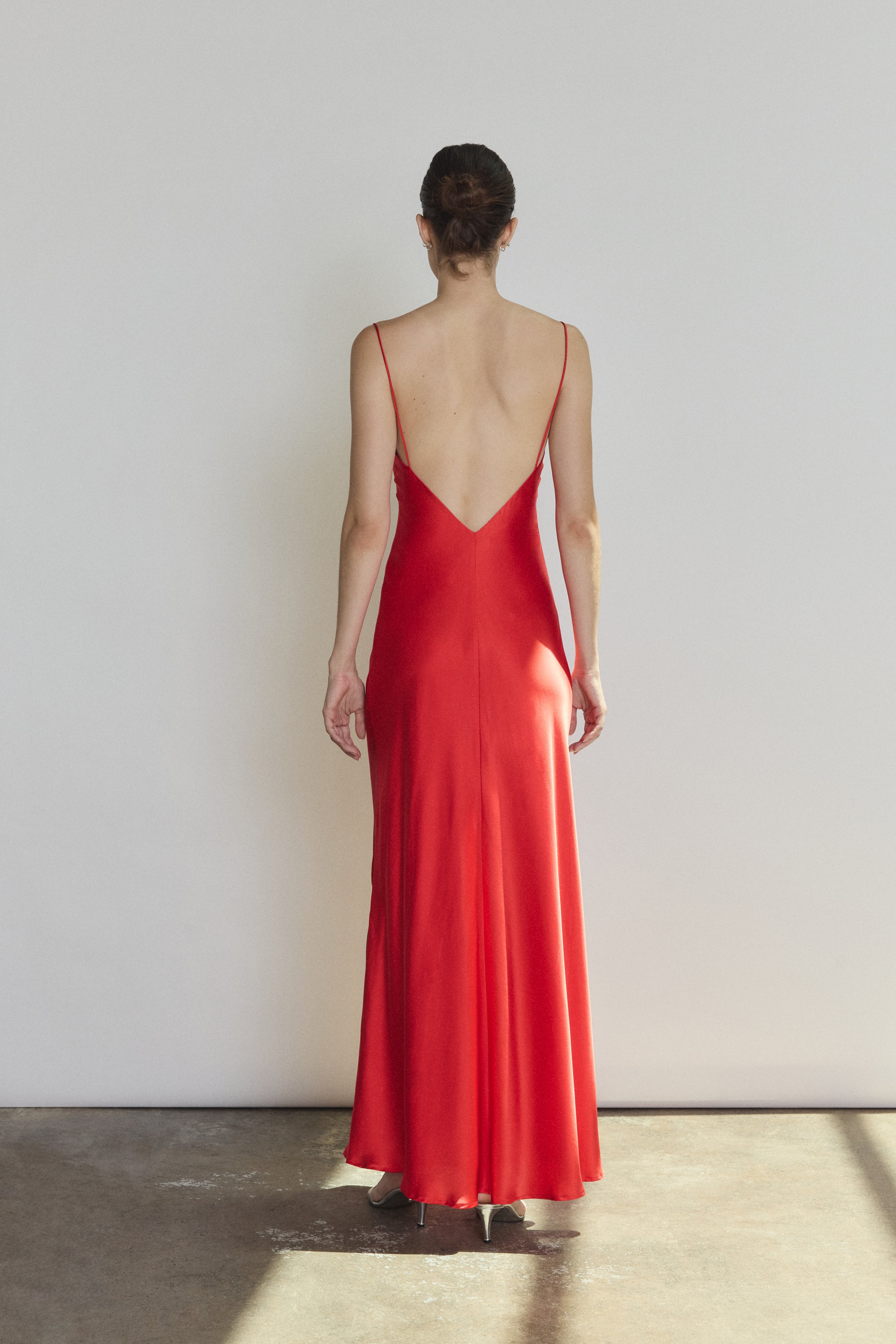 Back view of the crimson silk charmeuse Kamperett Caroline Slip Dress with V back and corded straps.