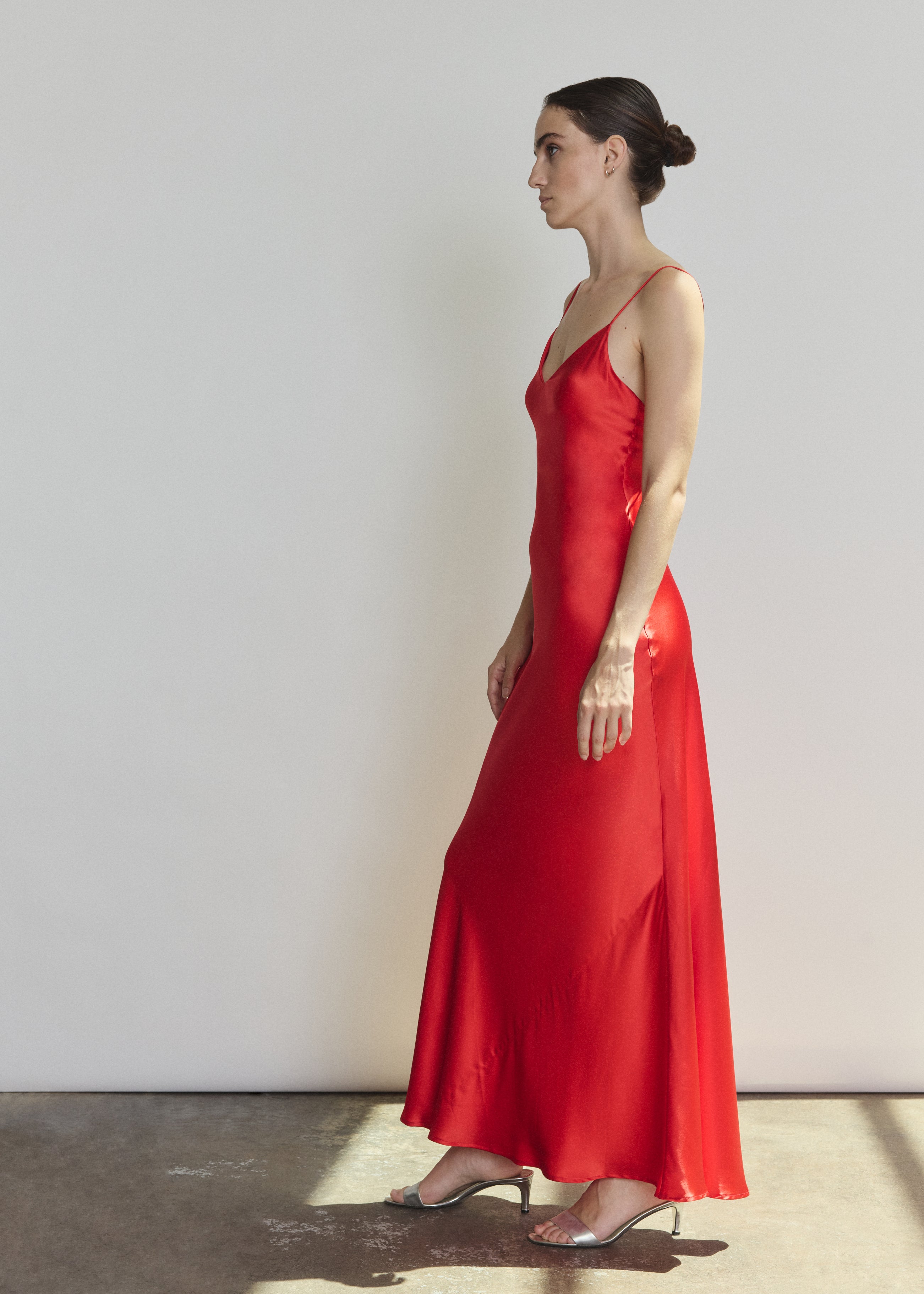 Side view of the crimson silk charmeuse Kamperett Caroline Slip Dress showing the bias-skimming silhouette.