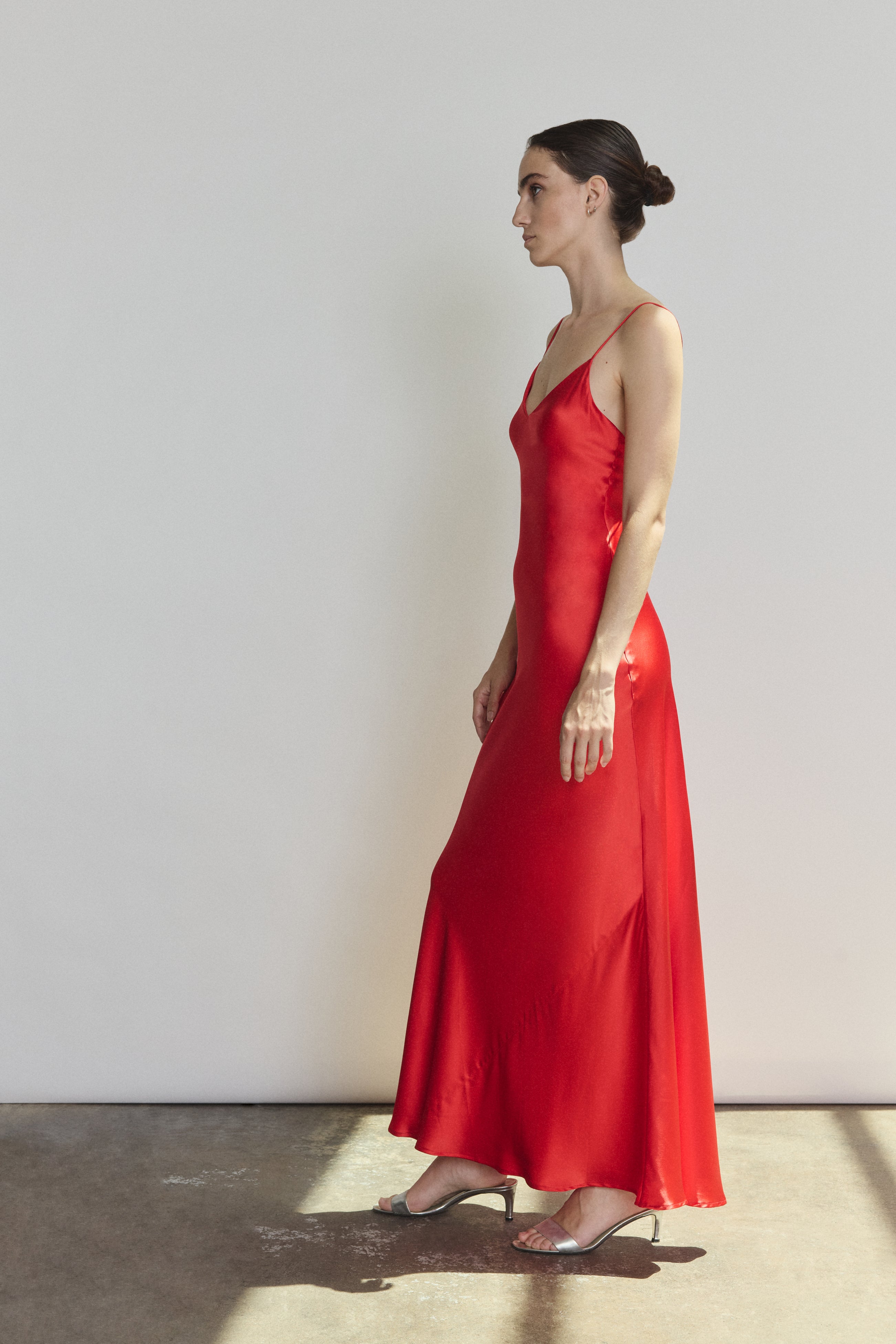 Side view of the crimson silk charmeuse Kamperett Caroline Slip Dress showing the bias-skimming silhouette.