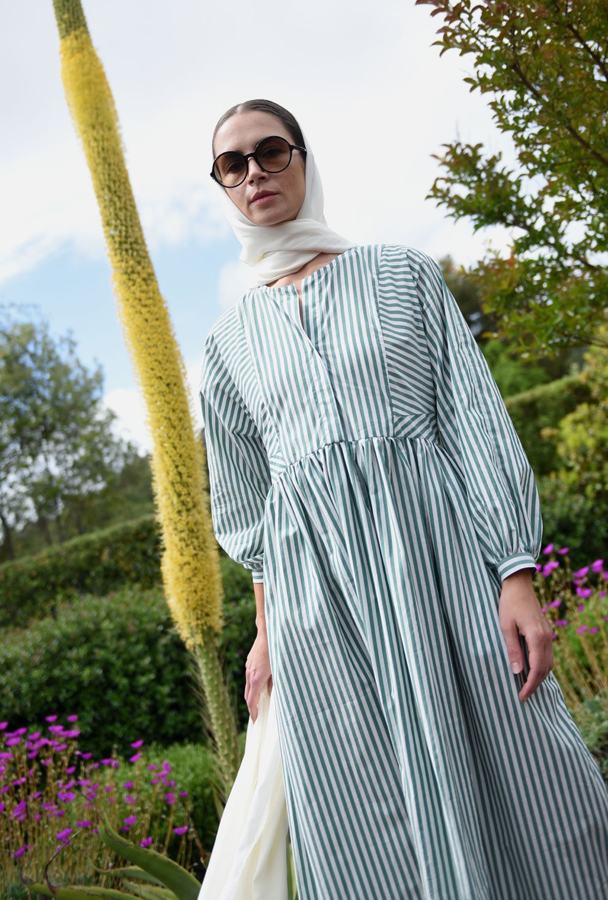 Front view of a model wearing the green stripe Japanese cotton Kamperett Cassatt Dress with dolman sleeves and gathered waist.