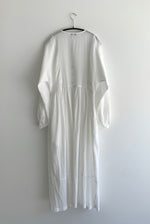 Close-up of the dolman sleeve and button cuff on the semi-sheer white stripe Kamperett Cassatt Dress.