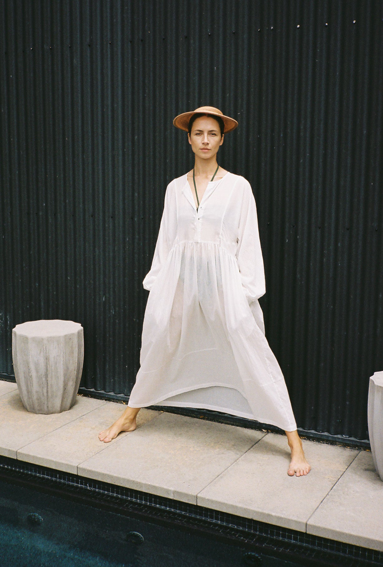 Front view of a model wearing the semi-sheer white stripe Japanese cotton voile Kamperett Cassatt Dress, with dolman sleeves.