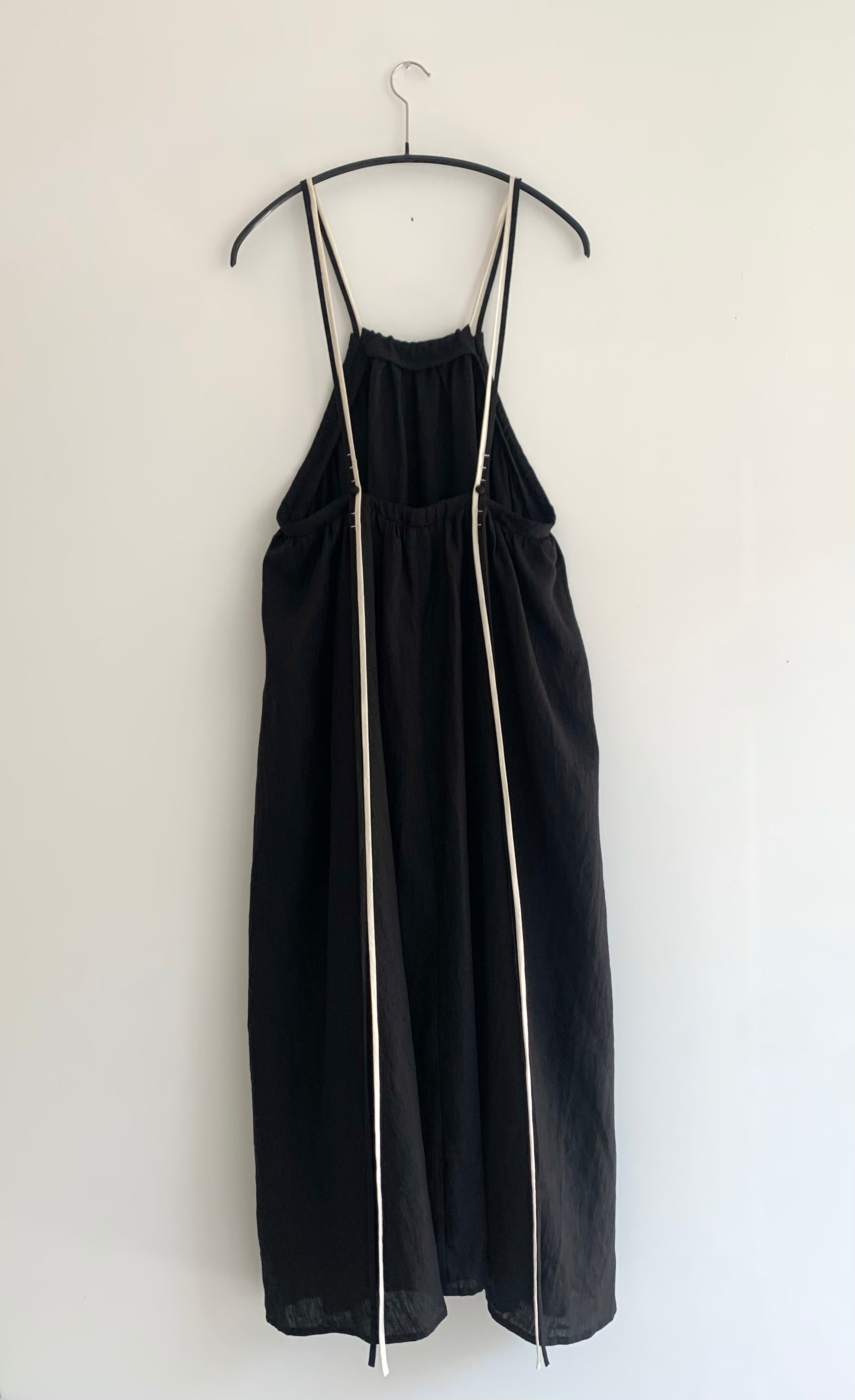 Back view of the black Japanese linen Kamperett Cosette Dress showing the adjustable corded back straps.