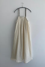 Front view of a model wearing the ivory Japanese linen Kamperett Cosette Dress with gathered neckline and trapeze silhouette.
