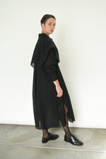 Close-up of the button front and sheer panel detail on the black Kamperett Etude Shirt Dress.