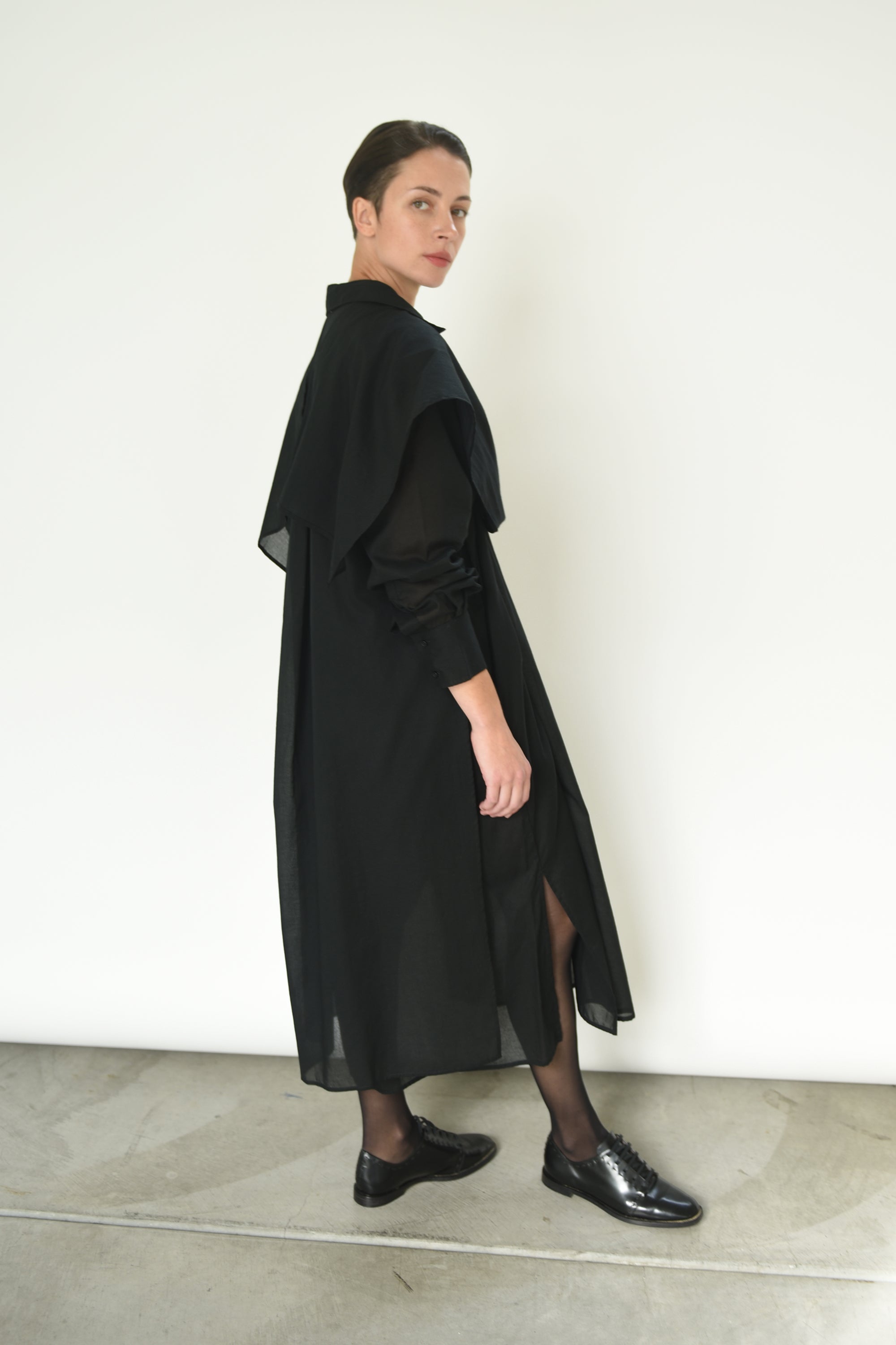 Close-up of the button front and sheer panel detail on the black Kamperett Etude Shirt Dress.