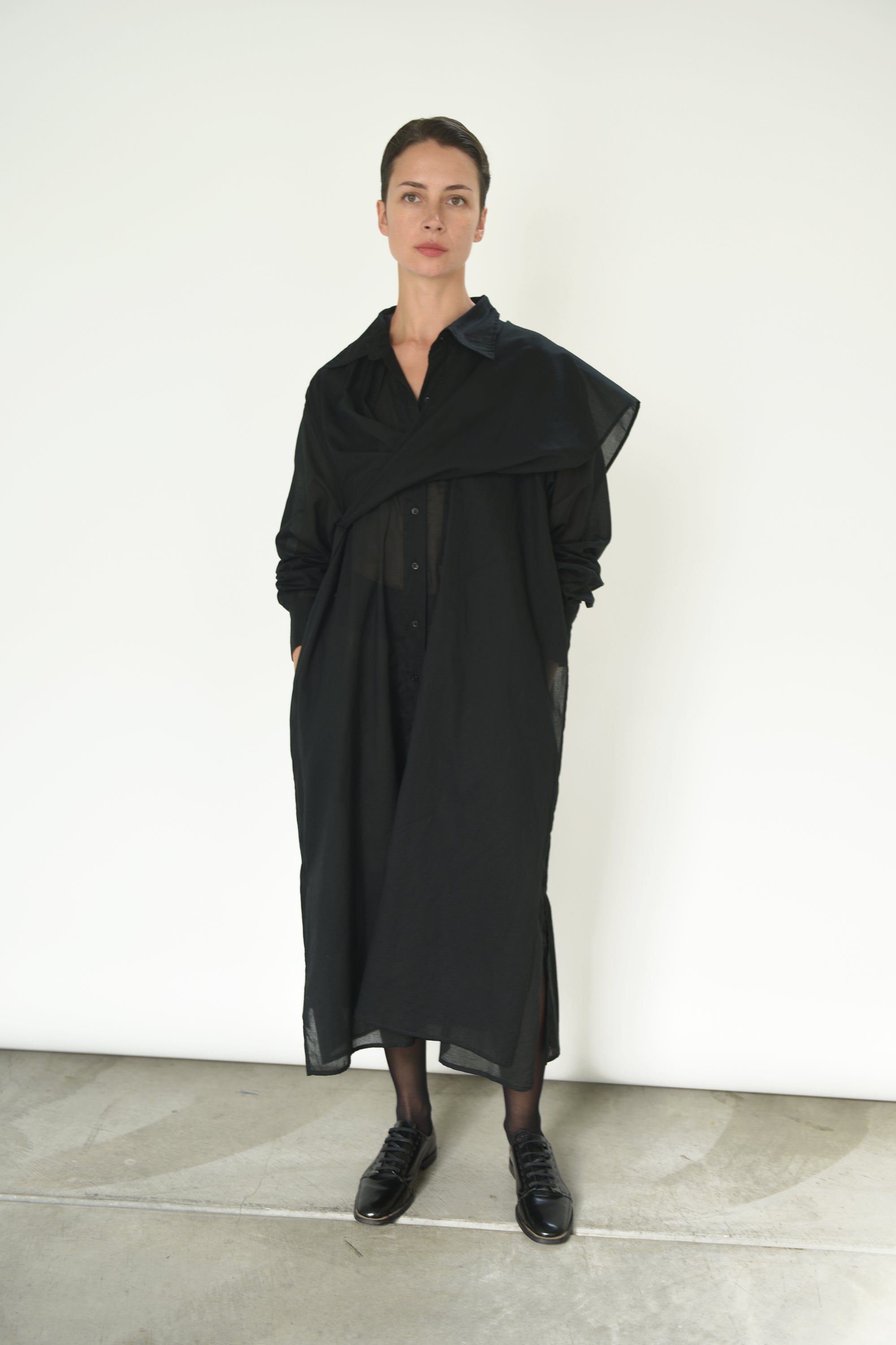 Motion shot of the black Japanese cotton voile Kamperett Etude Shirt Dress, capturing the fluid panel drape.