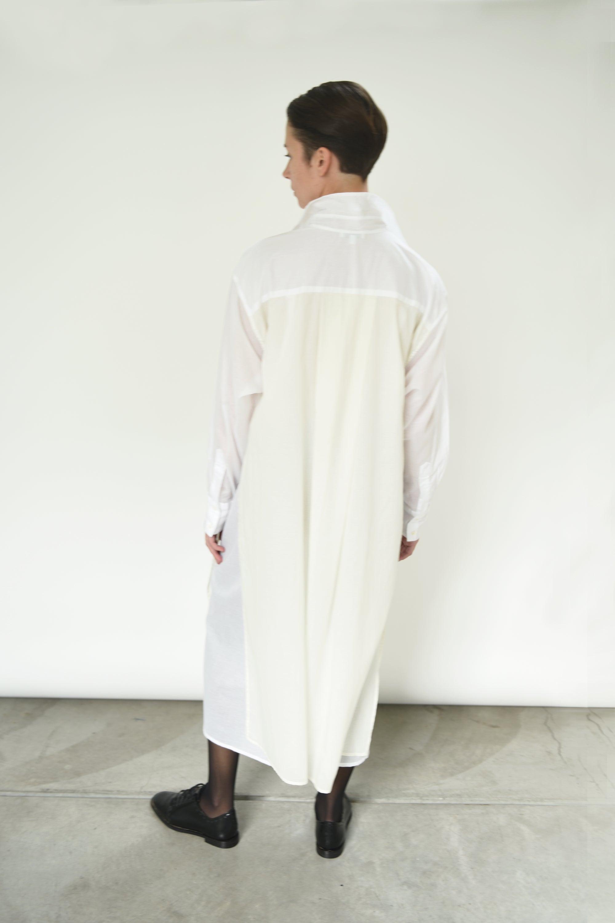 Close-up of the button front and sheer panel detail on the white Kamperett Etude Shirt Dress.