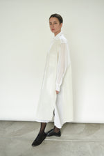 Editorial image of a model wearing the white Kamperett Etude Shirt Dress.