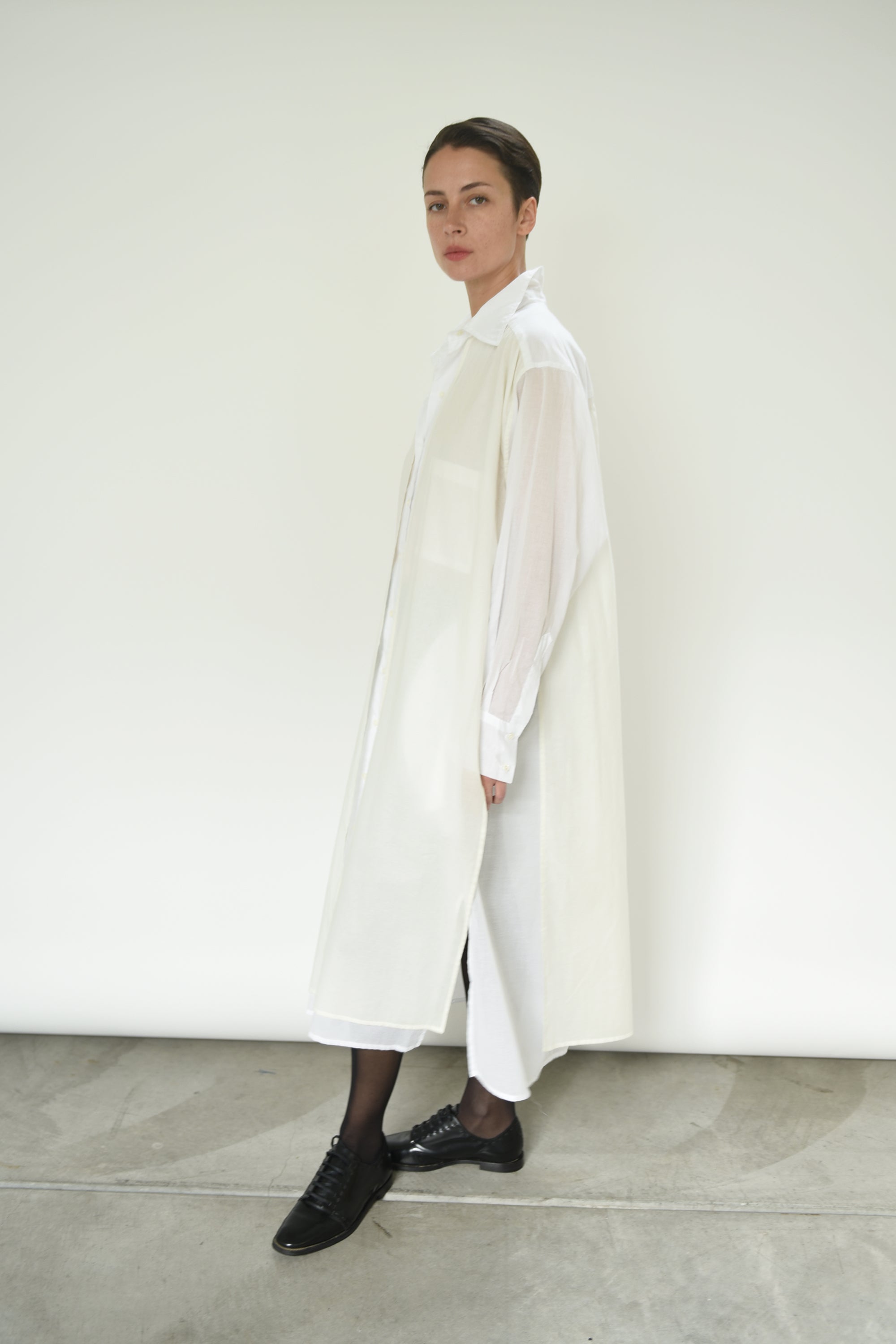 Editorial image of a model wearing the white Kamperett Etude Shirt Dress.