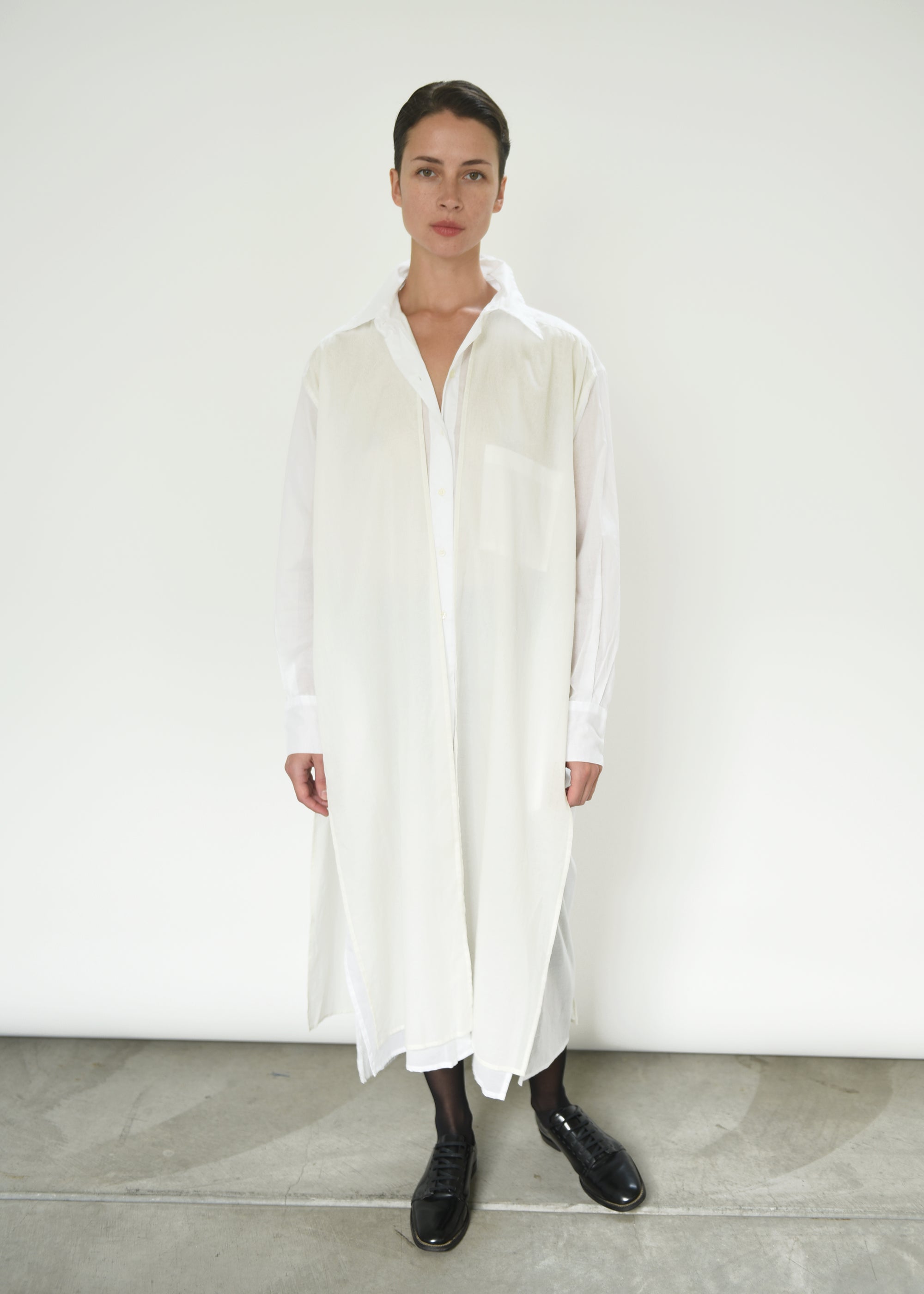 Front view of a model wearing the white semi-sheer Japanese cotton voile Kamperett Etude Shirt Dress.
